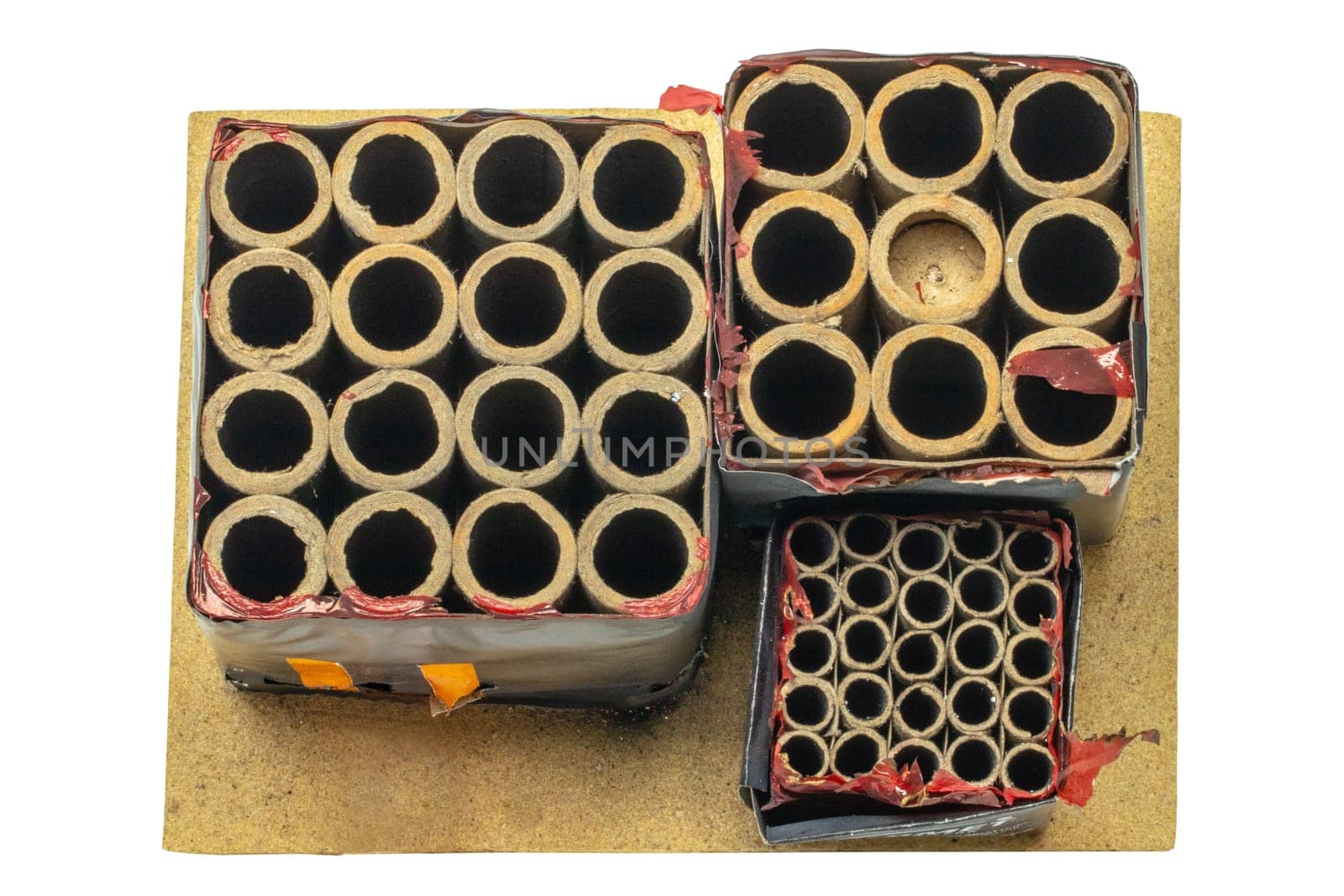 New Year's Eve waste or rubbish. Close-up of a used firework battery mounted on a wooden panel with a lot of shots. Fireworks shots. Clipping path. Top view.
