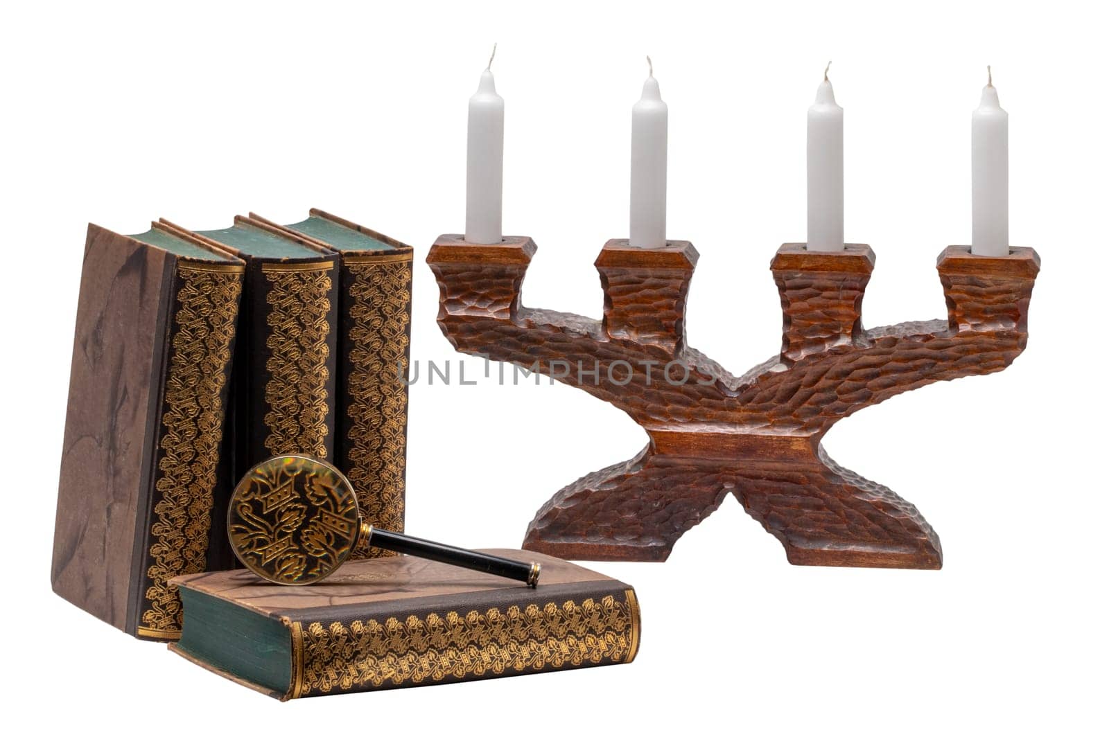 Ancient books with a magnifying glass and a antique wooden candle holder isolated on a white background. Clipping path. Education concept.