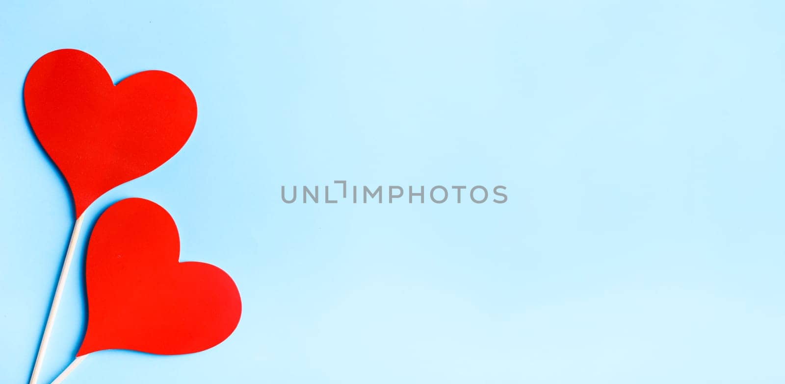 Red valentine hearts on pastel blue background from above. Valentine's day celebration banner. Creative minimal love concept. Hearts balloons top view. Valentine pop art colorful simple design layout.