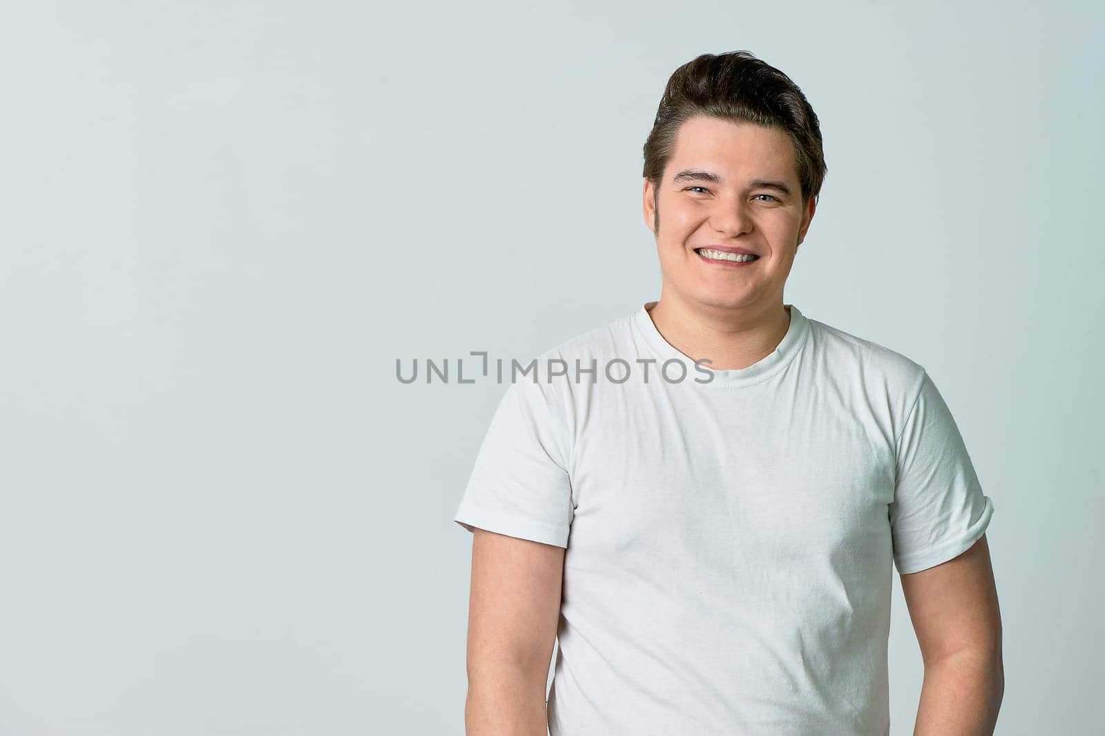 A man on a light background smiles. Emotions. Сopy space. High quality photo