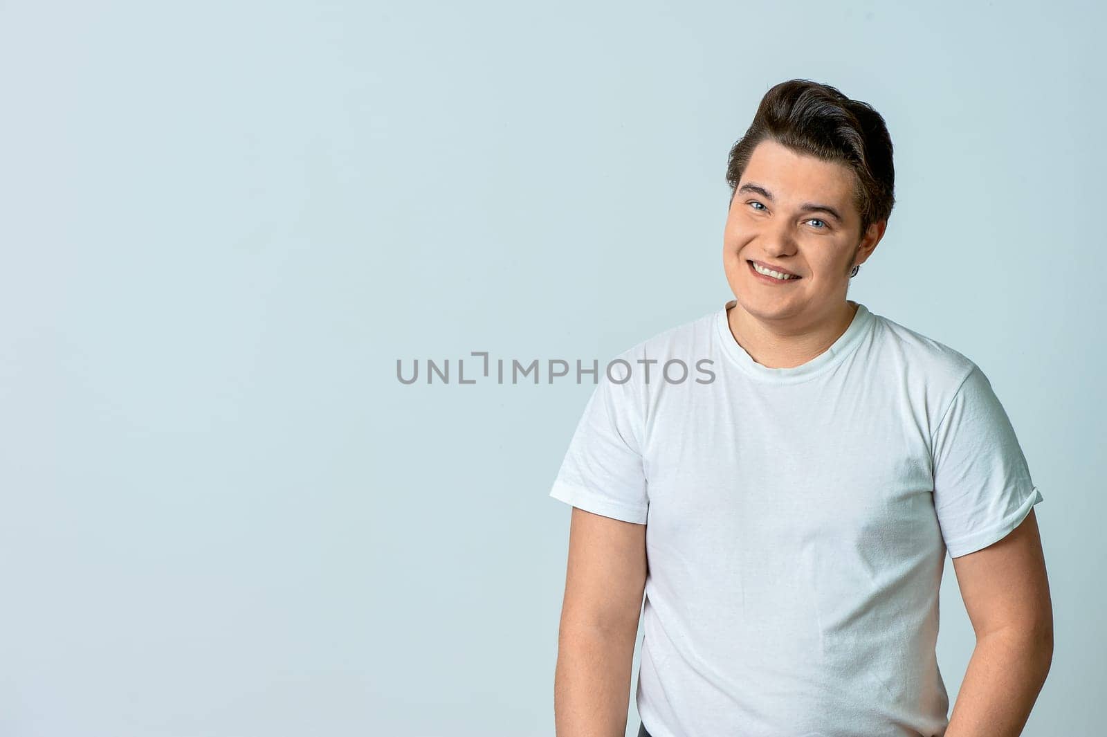 A man on a light background smiles. Emotions. High quality photo