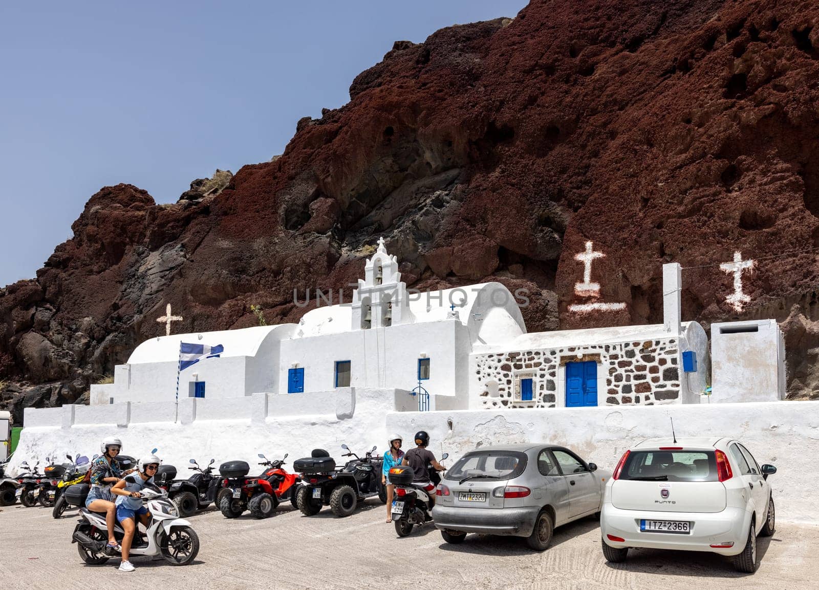 Santorini, Greece - July 01, 2021: Greek church built into the mountain located near the famous Red Beach of Akrotiri. Santorini Island, Greece