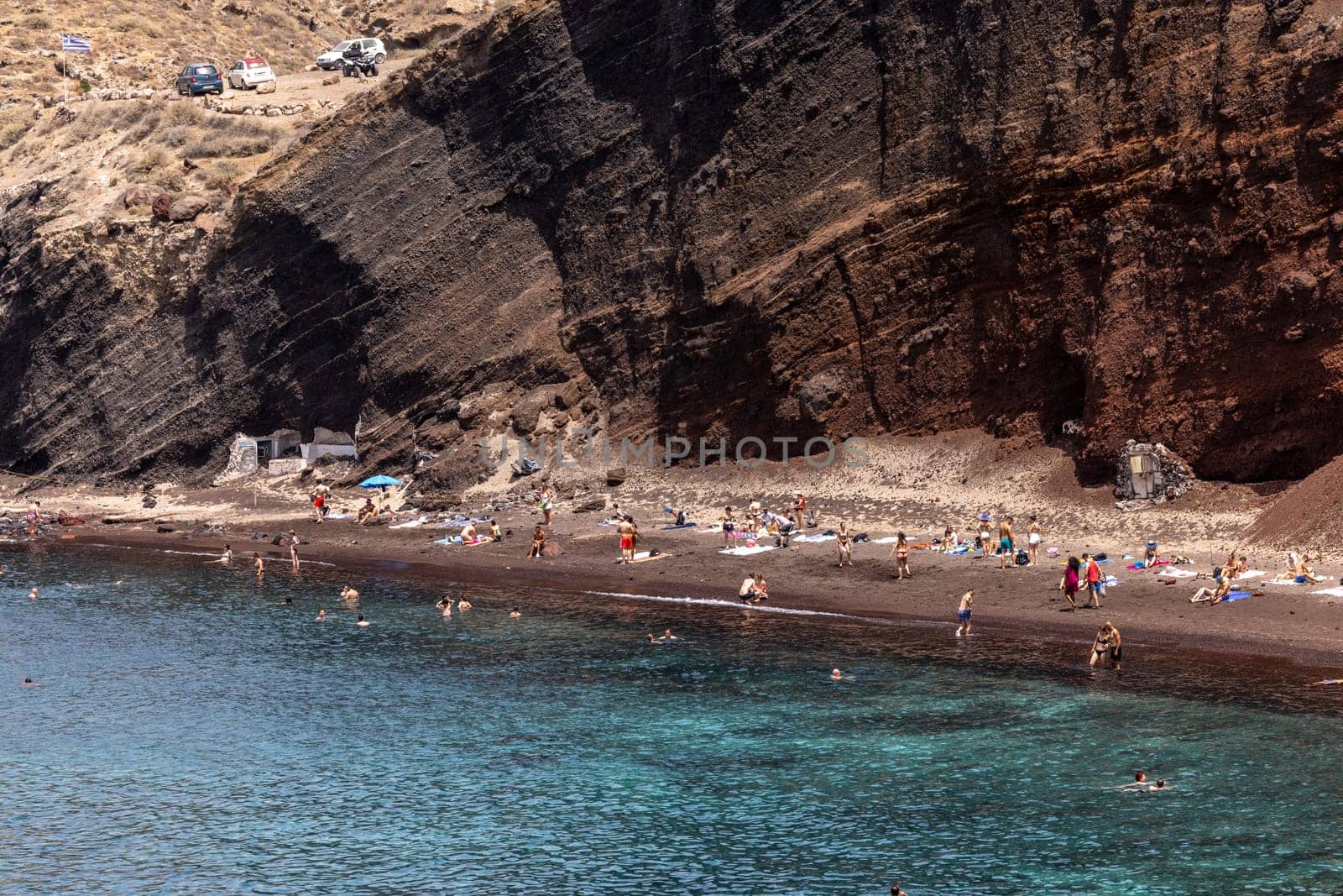 Santorini, Greece - July 01, 2021: The famous Red beach on the south coast of Santorini island, Cyclades, Aegean Sea.