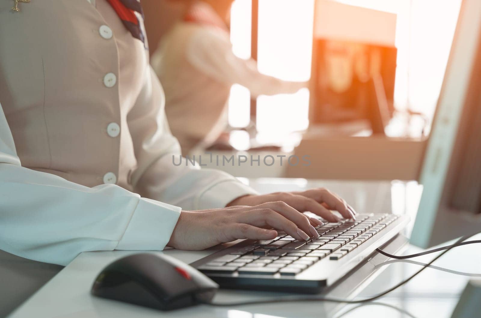 Female officers working at airline check in service counter. Close up of woman hand typing on PC computer keyboard.