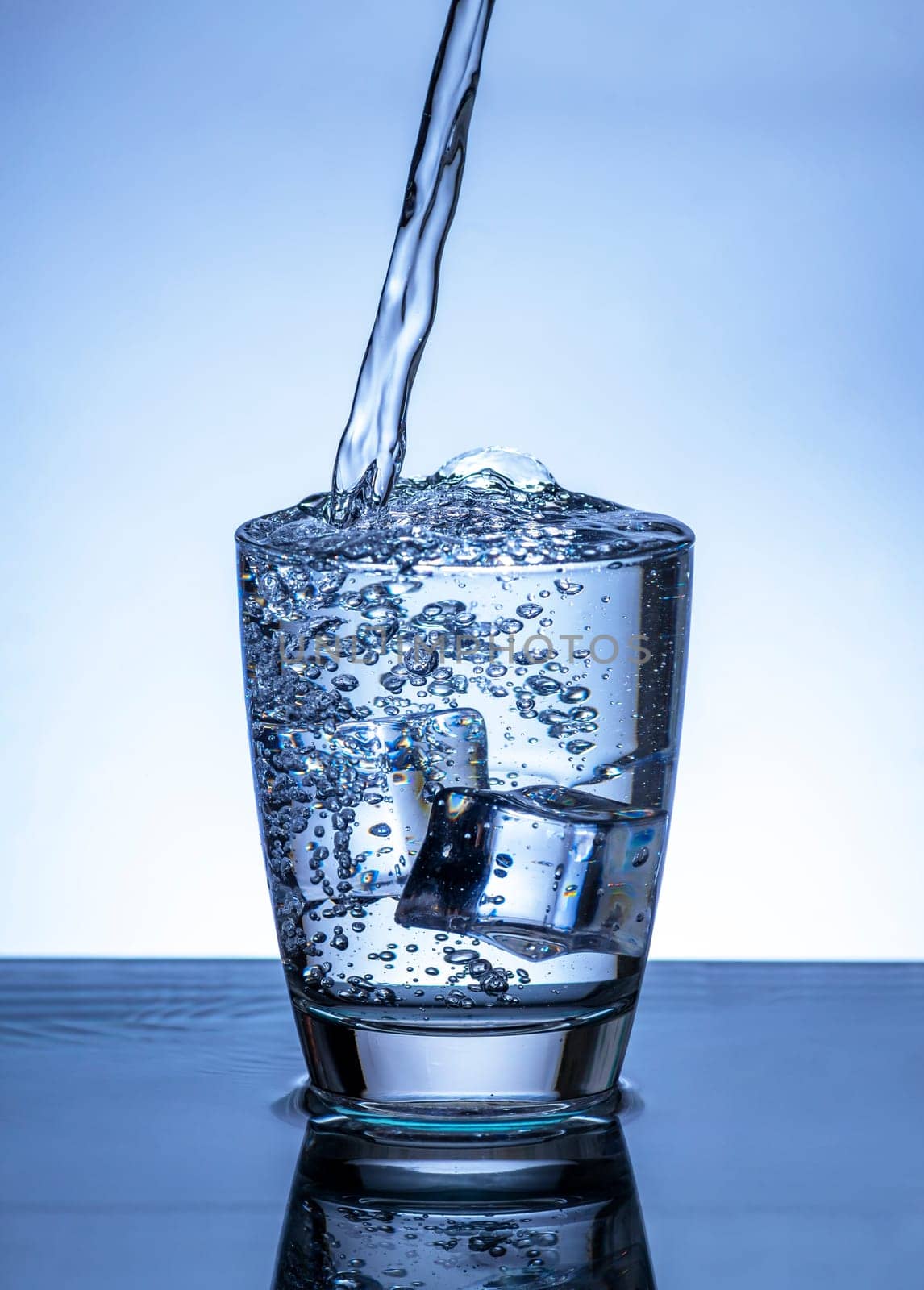 The image of pouring drinking water, into a glass, that makes one feel refreshed on blurred white background, Splashing water, Sparkling water
