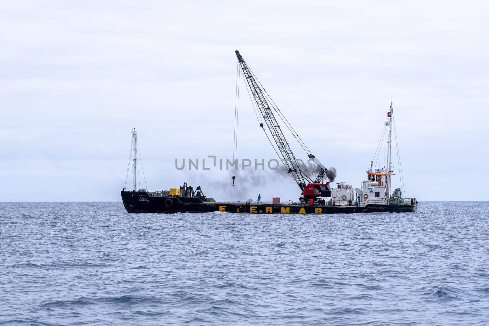 Madeira / Portugal - July 15, 2021. The industrial ship with workers moored at Madeira coast.