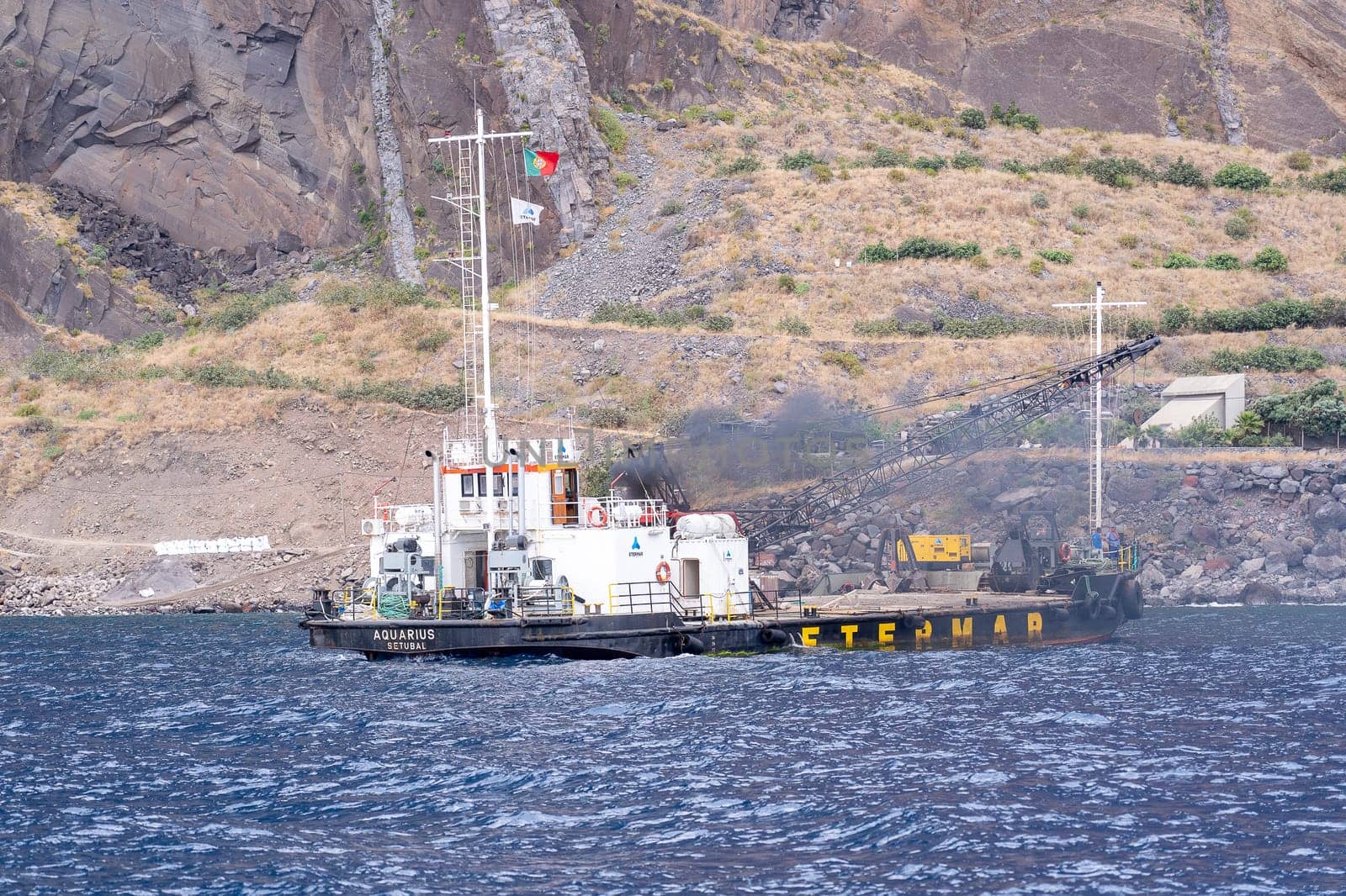 Madeira / Portugal - July 15, 2021. The industrial ship with workers moored at Madeira coast.