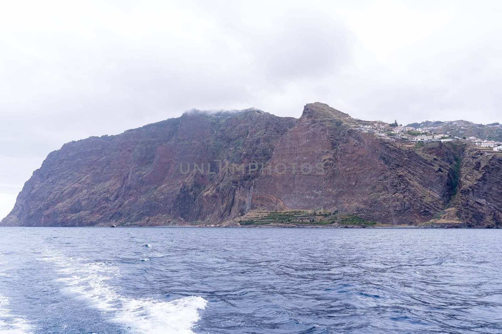 View of sheer volcanic cliff rising above ocean.