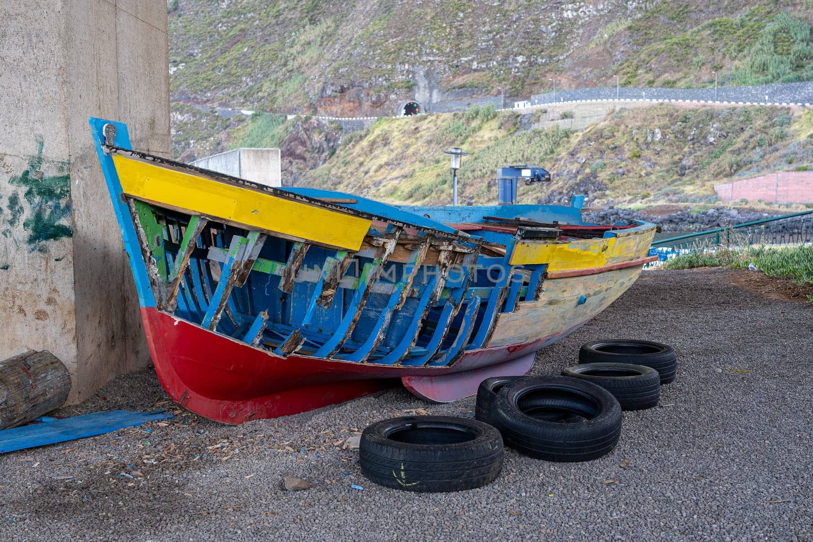 Skeleton of an old, damaged wooden boat on the seashore on the Porto moniz, Madeira island.