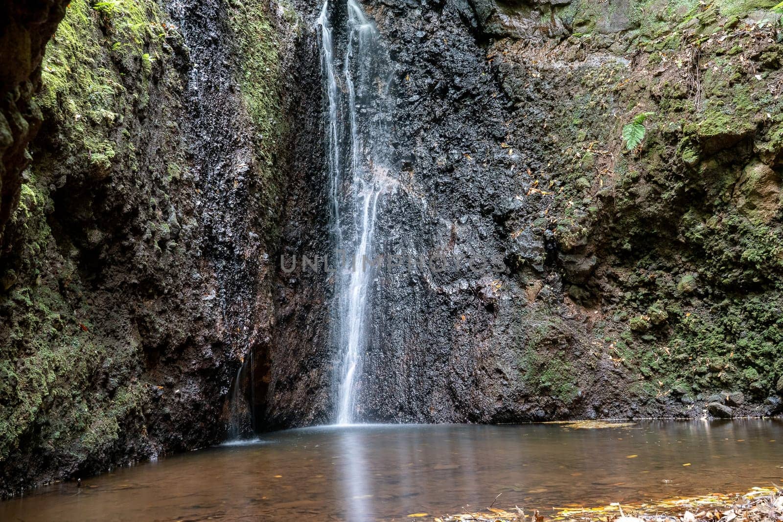 Waterfall among rocks. Madeira Island, Portugal, Europe. Long exposure photo.