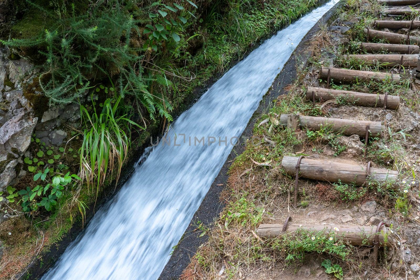 The path by beautiful irrigation canal named levadas in Madeira island, Portugal.