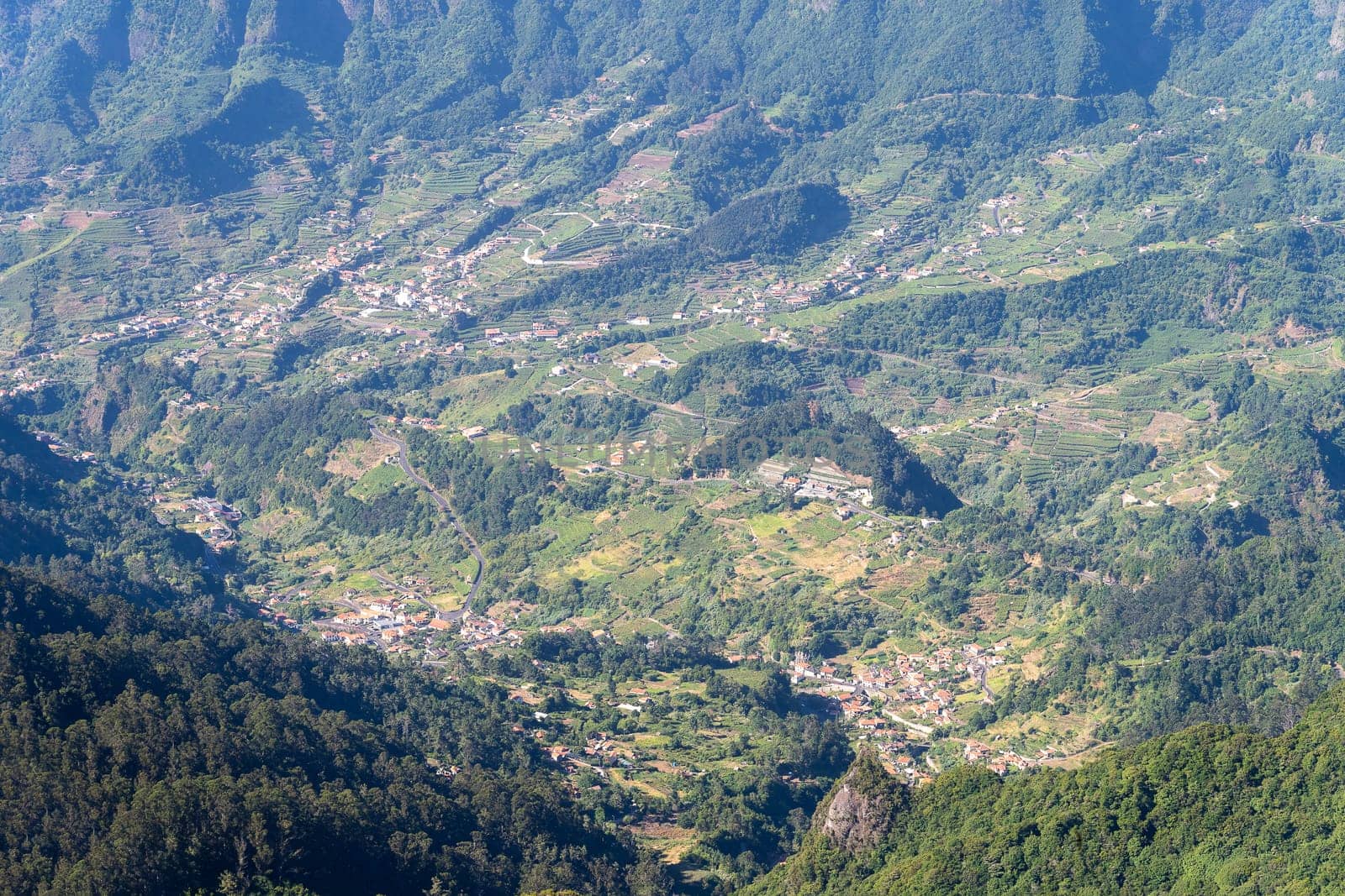 Aerial view on small city, huge mountains on background. Madeira island, Portugal.