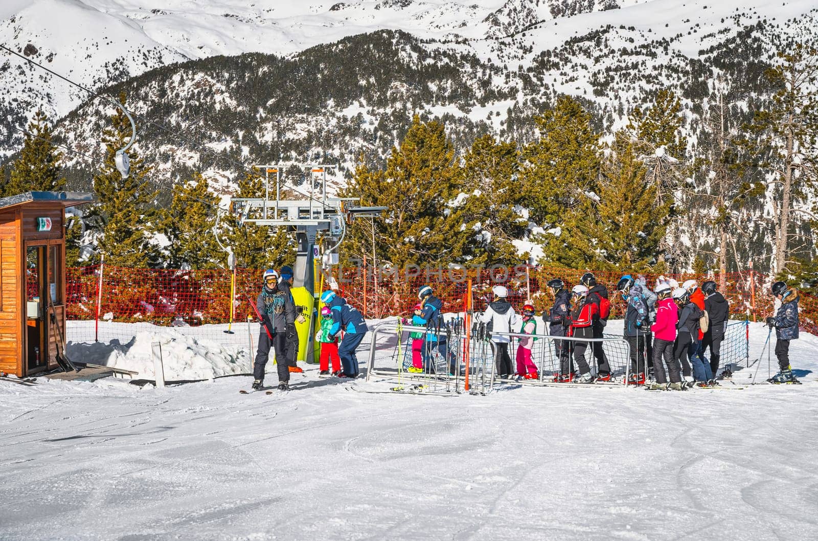 El Tarter, Andorra, Jan 2020 Ski instructor teaching a group of young kids how to ski and get on ski drag lift. Winter holidays in Pyrenees Mountains