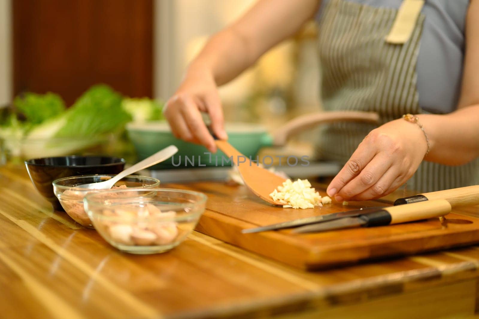 Cropped shot of woman preparing fresh ingredients on a rustic wooden countertop.