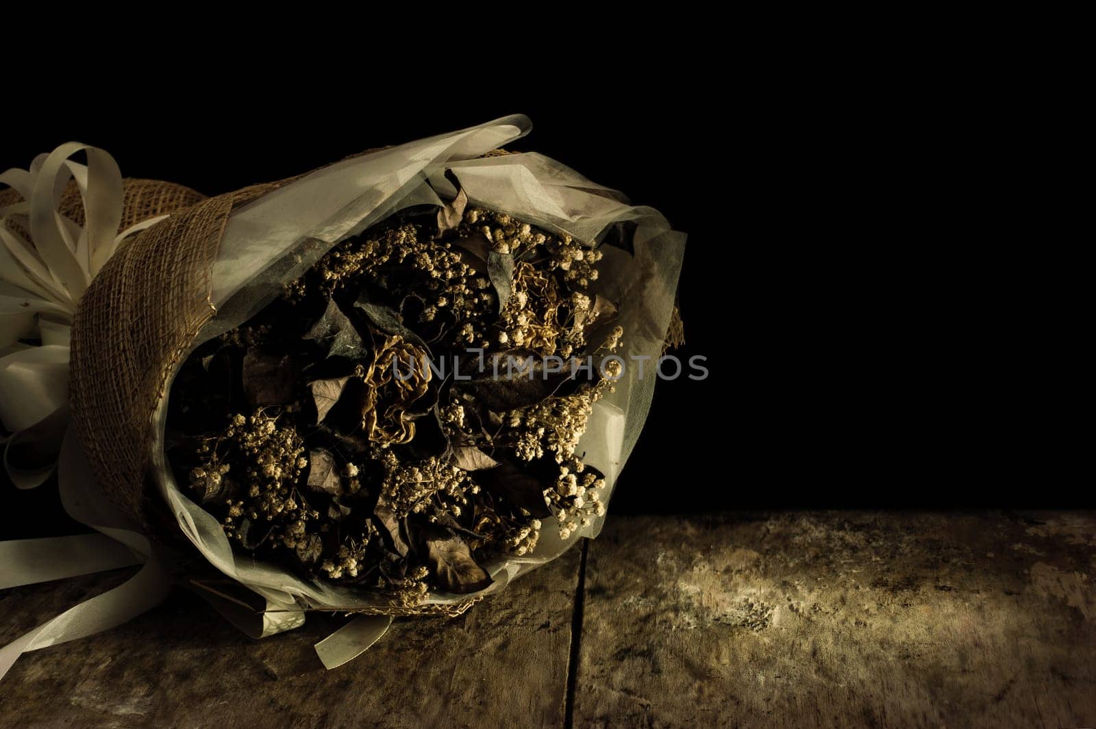 Still life with flower on black background and old wooden table, Dried flowers preserved as a memorial and feelings of the past in the past.