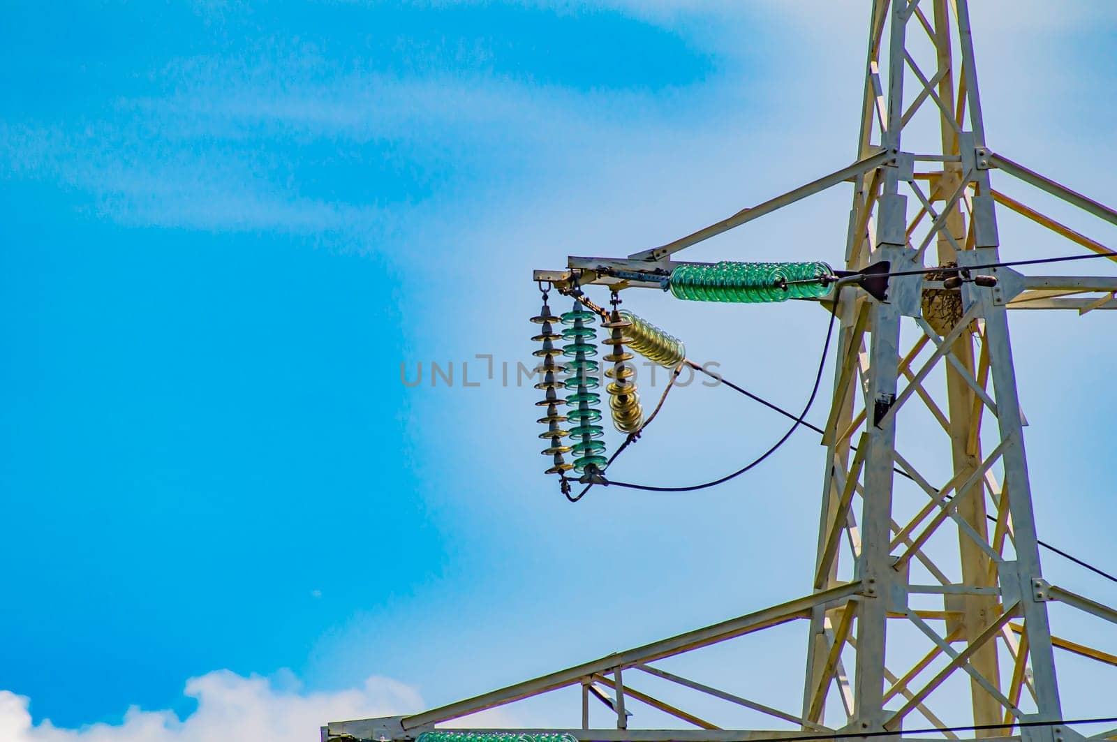 Line insulator on the electrical wires of a high-voltage tower. Electric wires. High-voltage power transmission tower. Electrical line insulators. Energy business. The beauty.