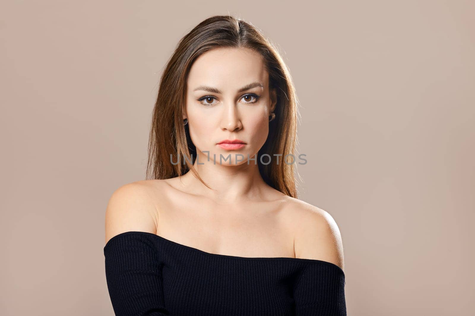 Medium closeup portrait of sad woman over beige background