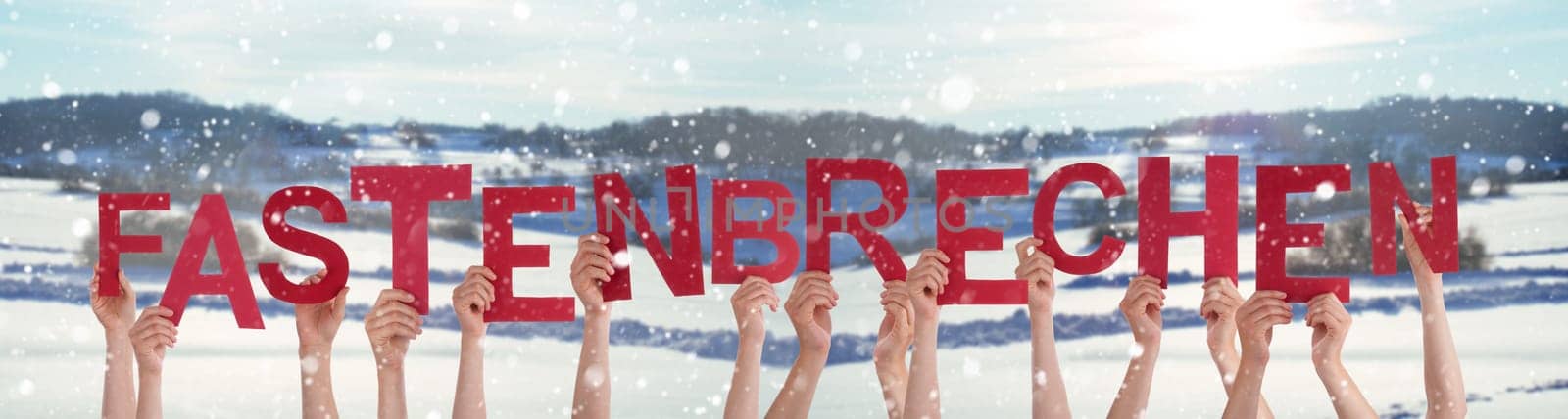 People Hands Holding Red German Word Fastenbrechen Means Fast-Breaking. Snowy Winter Background With Snowflakes