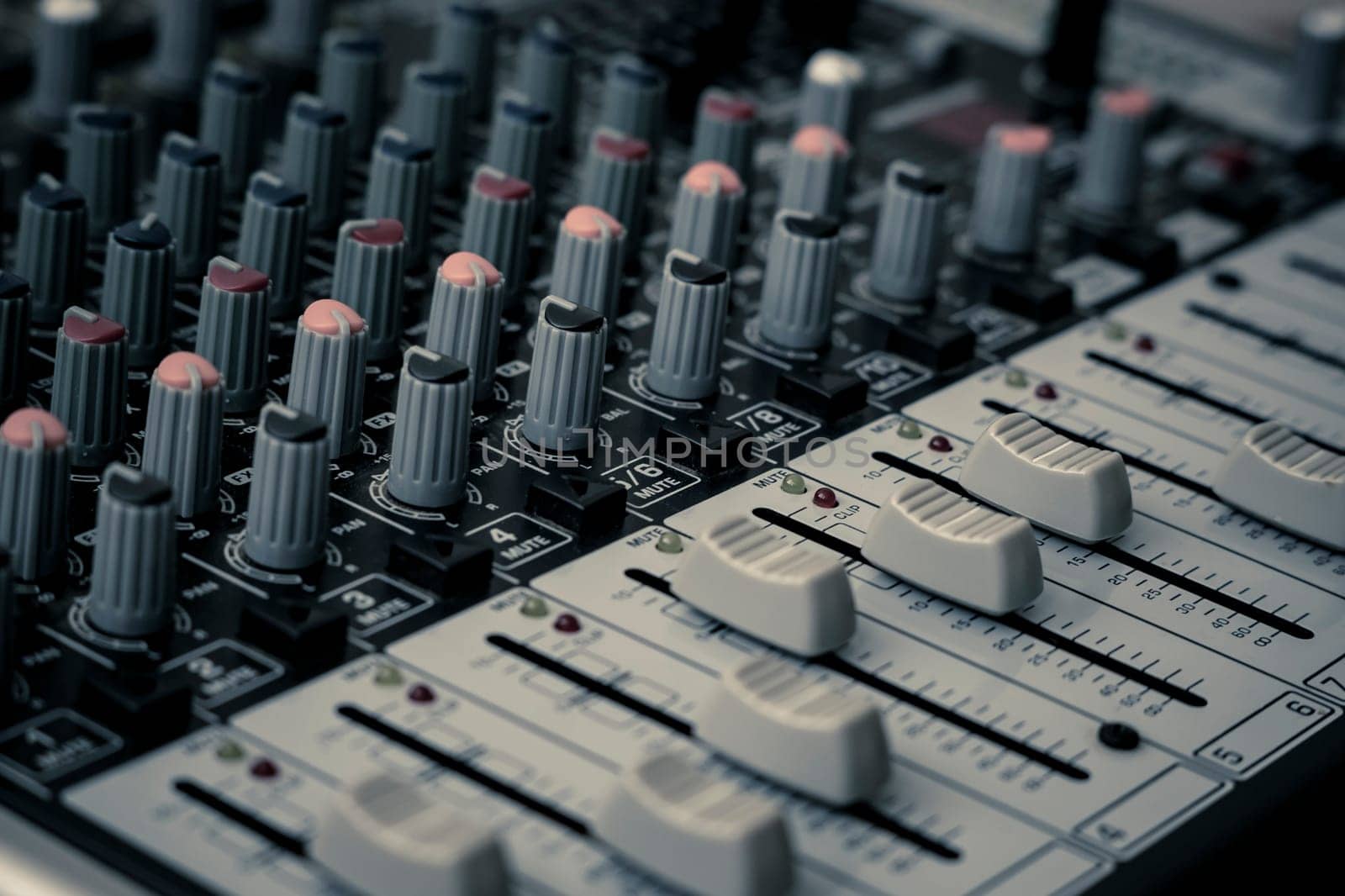 Closeup and detail of audio mixing console with faders and knobs. used for audio production