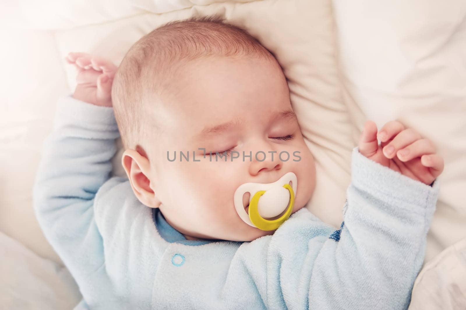 Cute three month old baby sleeping in comfortable bed. Concept of the family andparenting.