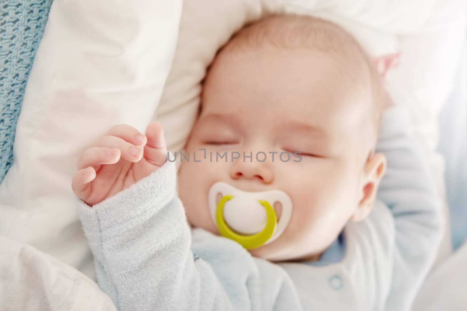 Cute three month old baby sleeping in comfortable bed. Concept of the family andparenting.