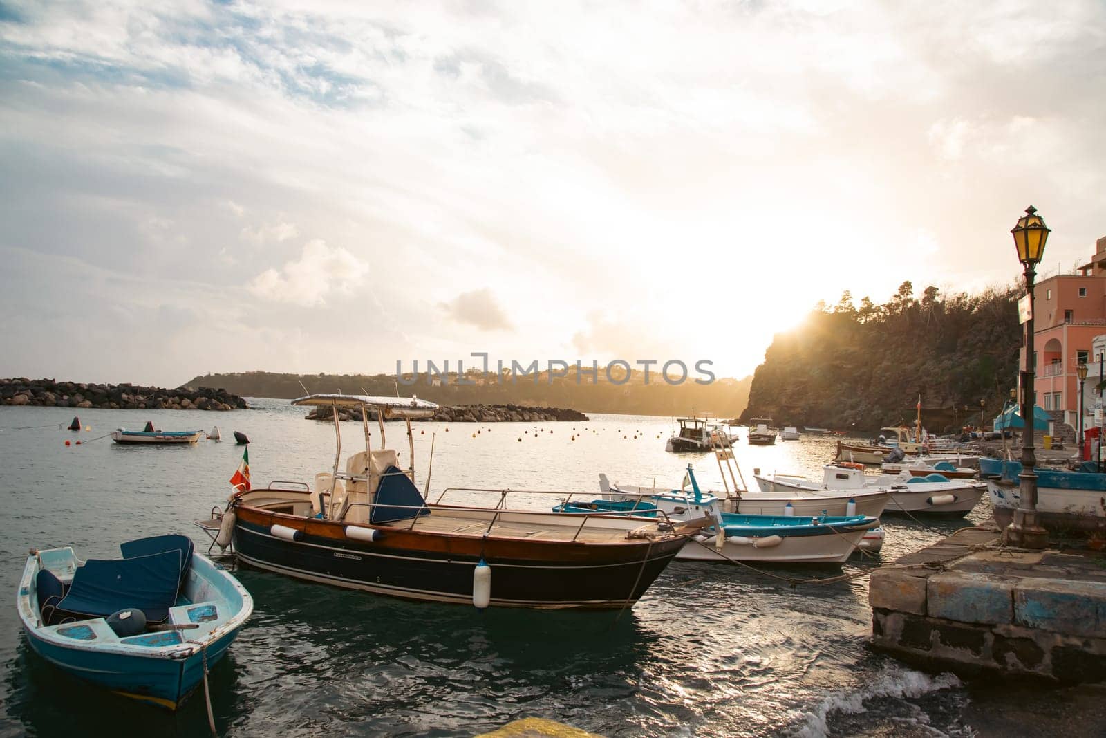 View of the Port of Corricella with lots of colorful houses on a sunny day in Procida Island, Italy.
