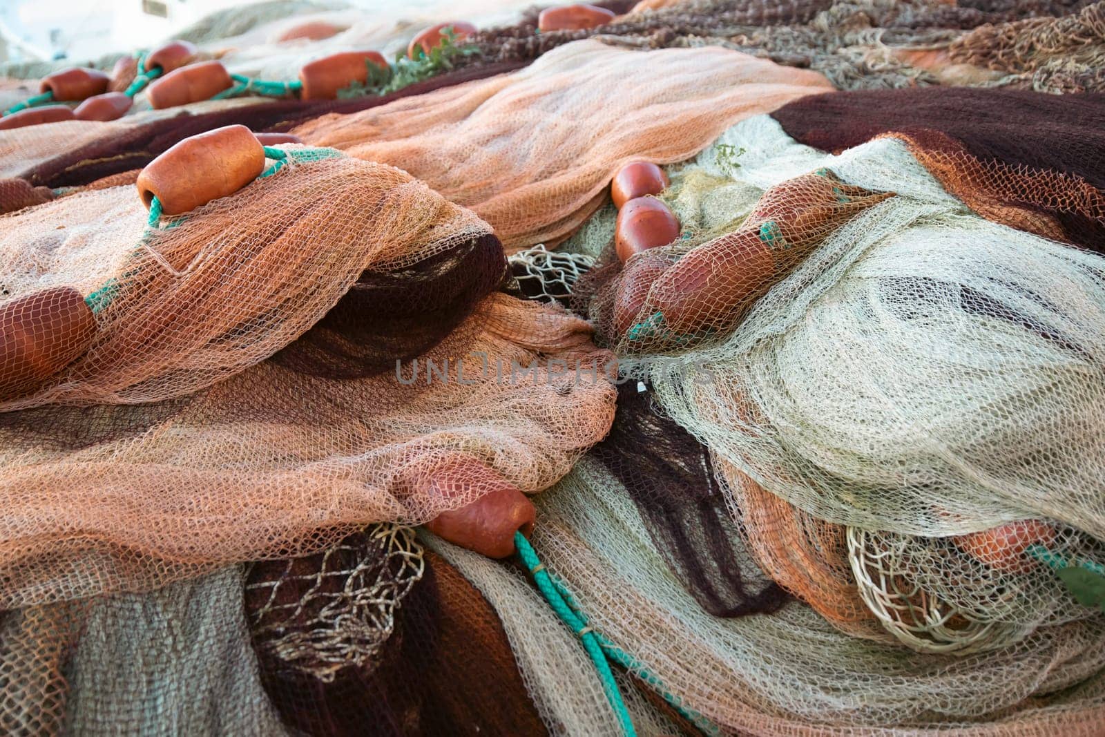 Fishing nets the Port of Corricella with lots of colorful houses on a sunny day in Procida Island, Italy.