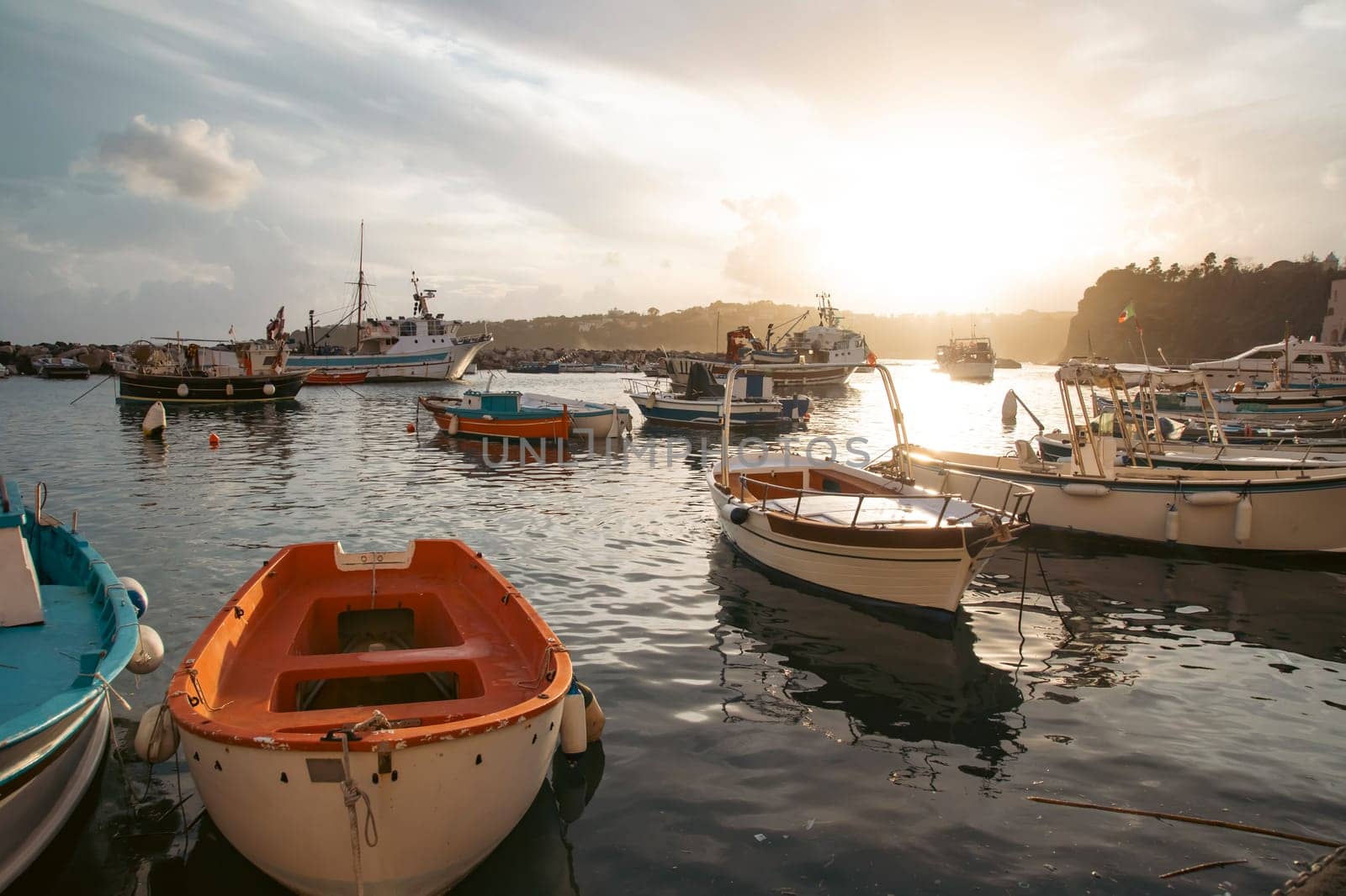 View of the Port of Corricella with lots of colorful houses on a sunny day in Procida Island, Italy.