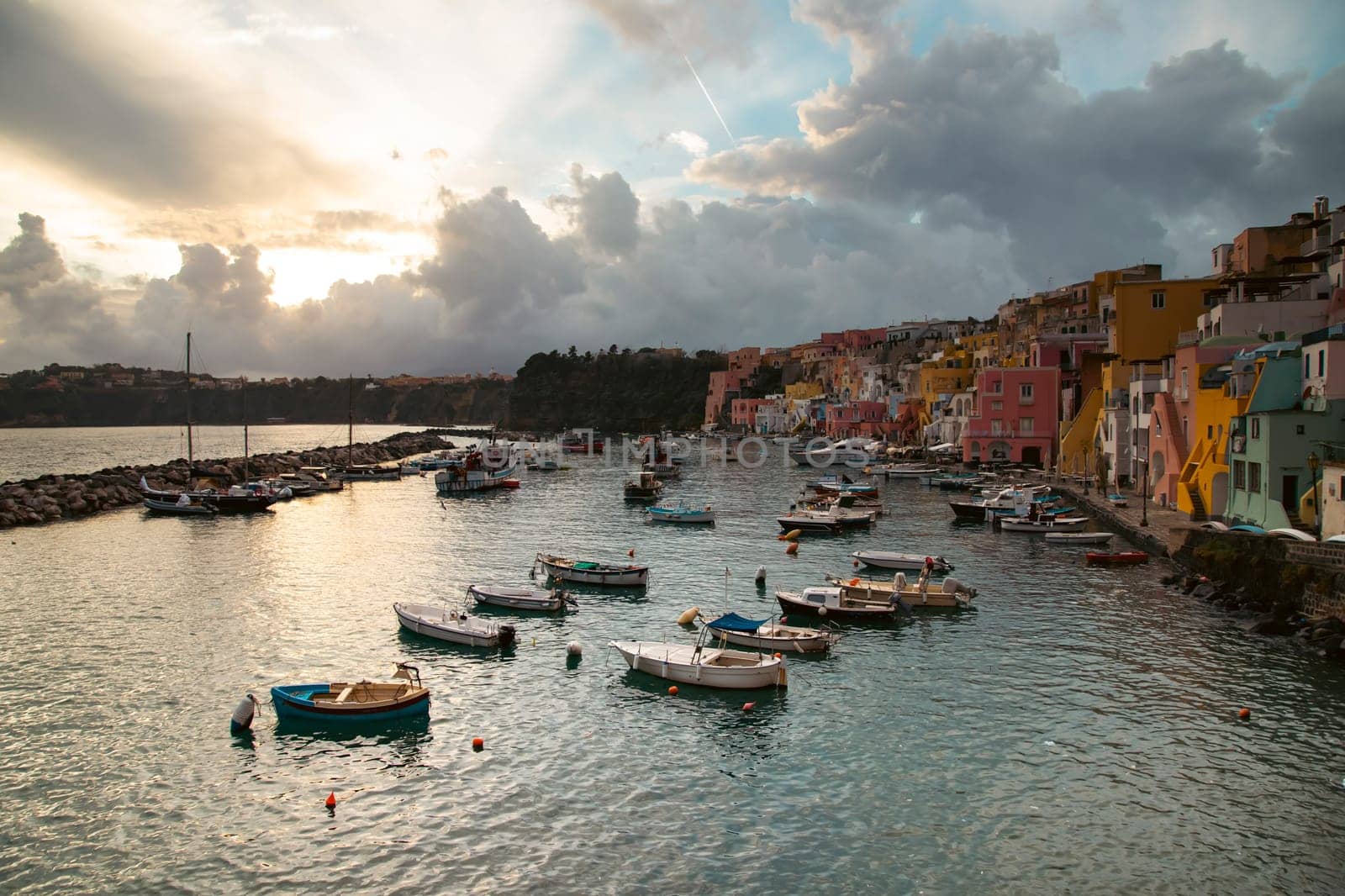 View of the Port of Corricella with lots of colorful houses on a sunny day in Procida Island, Italy.