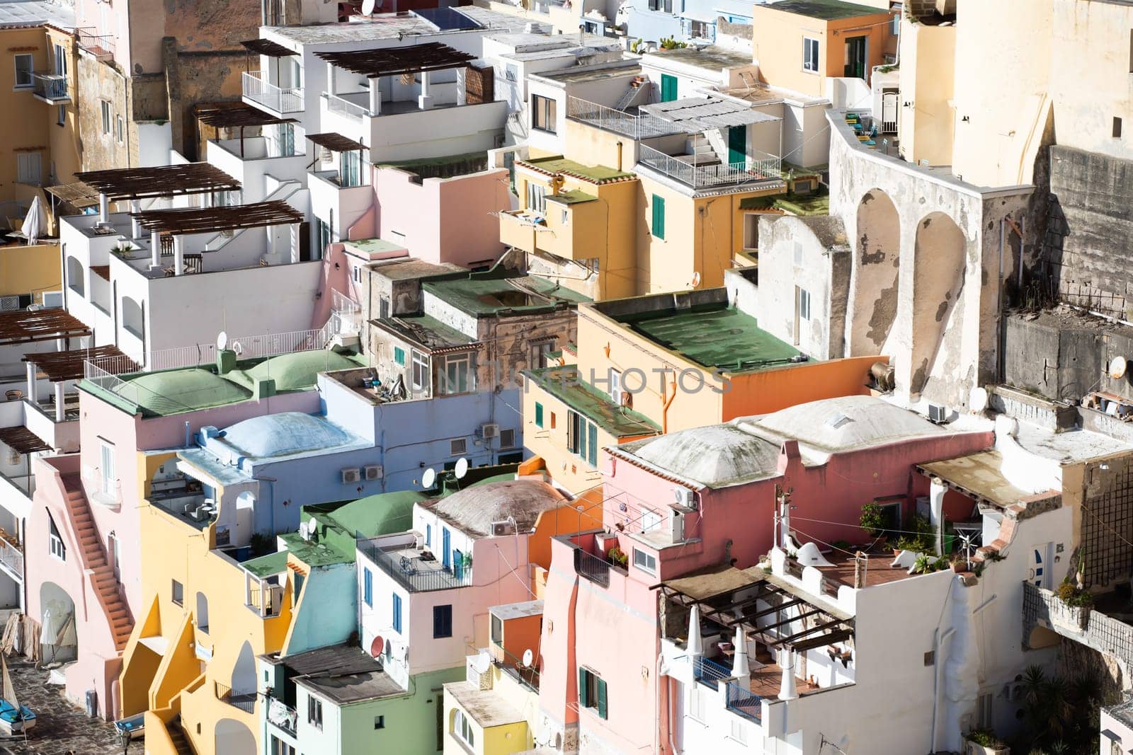 View of the Port of Corricella with lots of colorful houses on a sunny day in Procida Island, Italy.