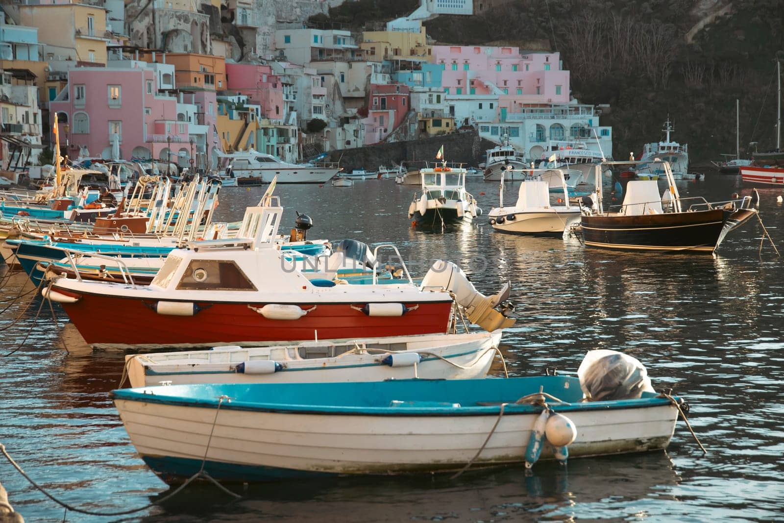 View of the Port of Corricella with lots of colorful houses on a sunny day in Procida Island, Italy.