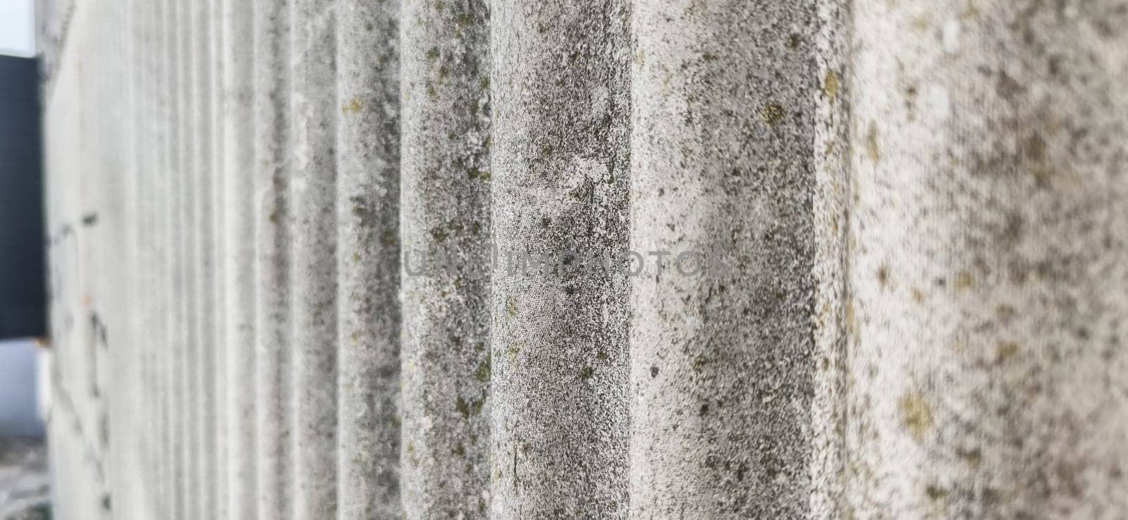 Wall protected with fibre cement corrugated sheets. Disused construction material for containing elements harmful to human health