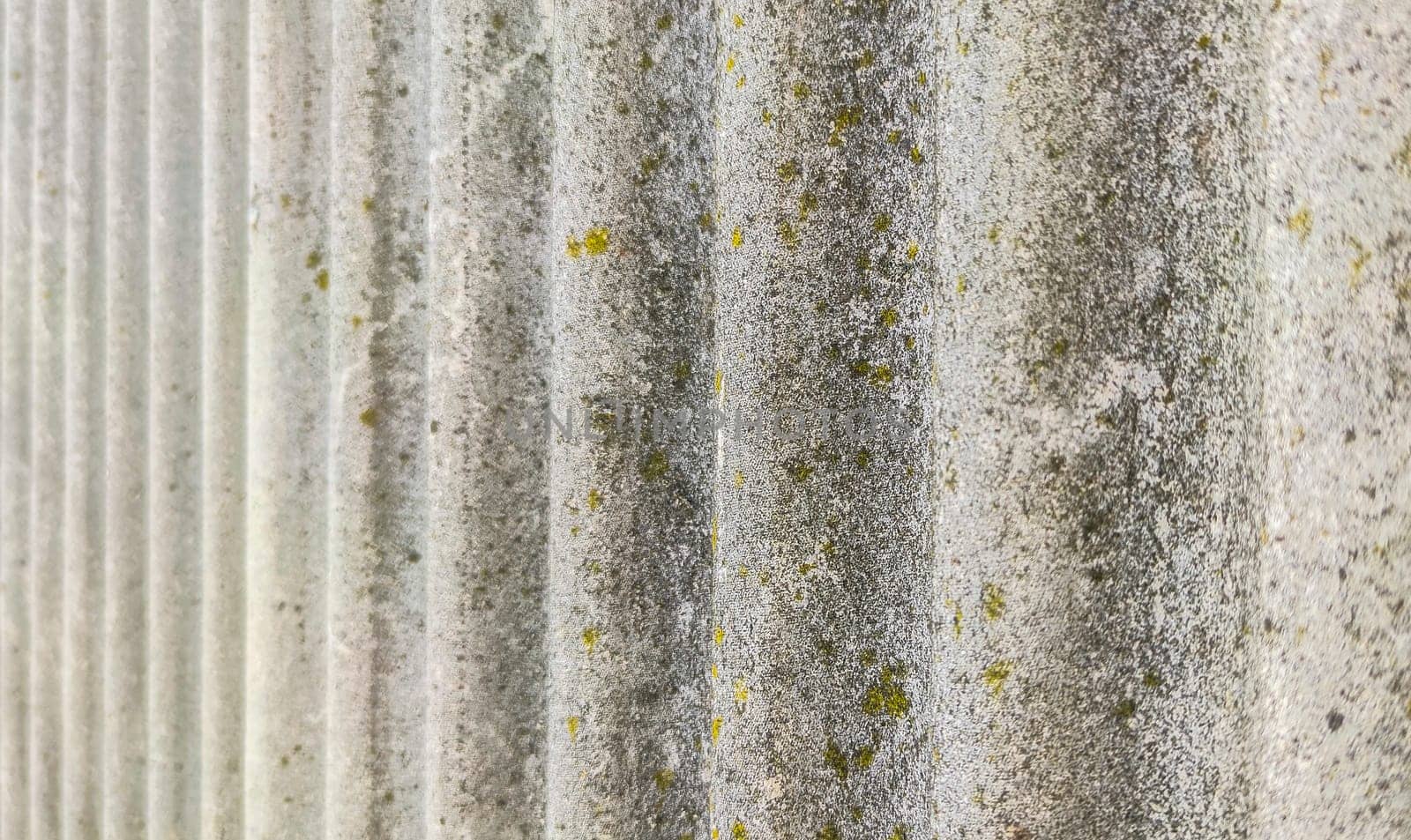 Wall protected with fibre cement corrugated sheets. Disused construction material for containing elements harmful to human health
