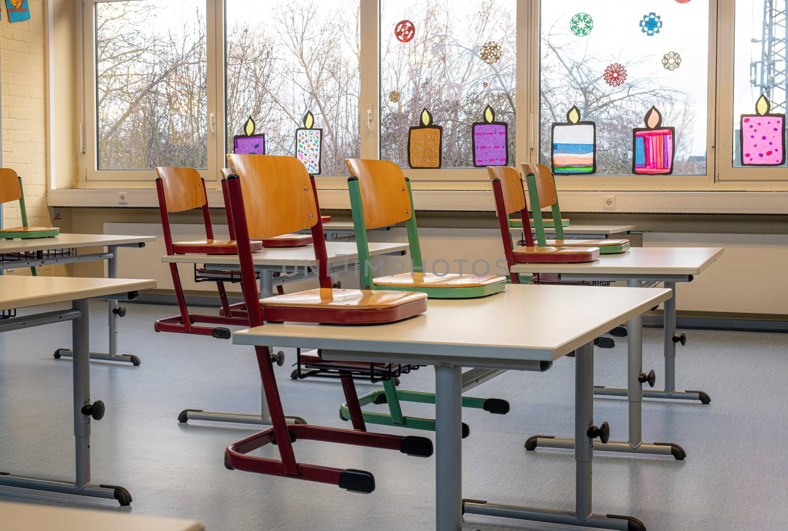 Red chair in a classroom stands on a table against a blurred background