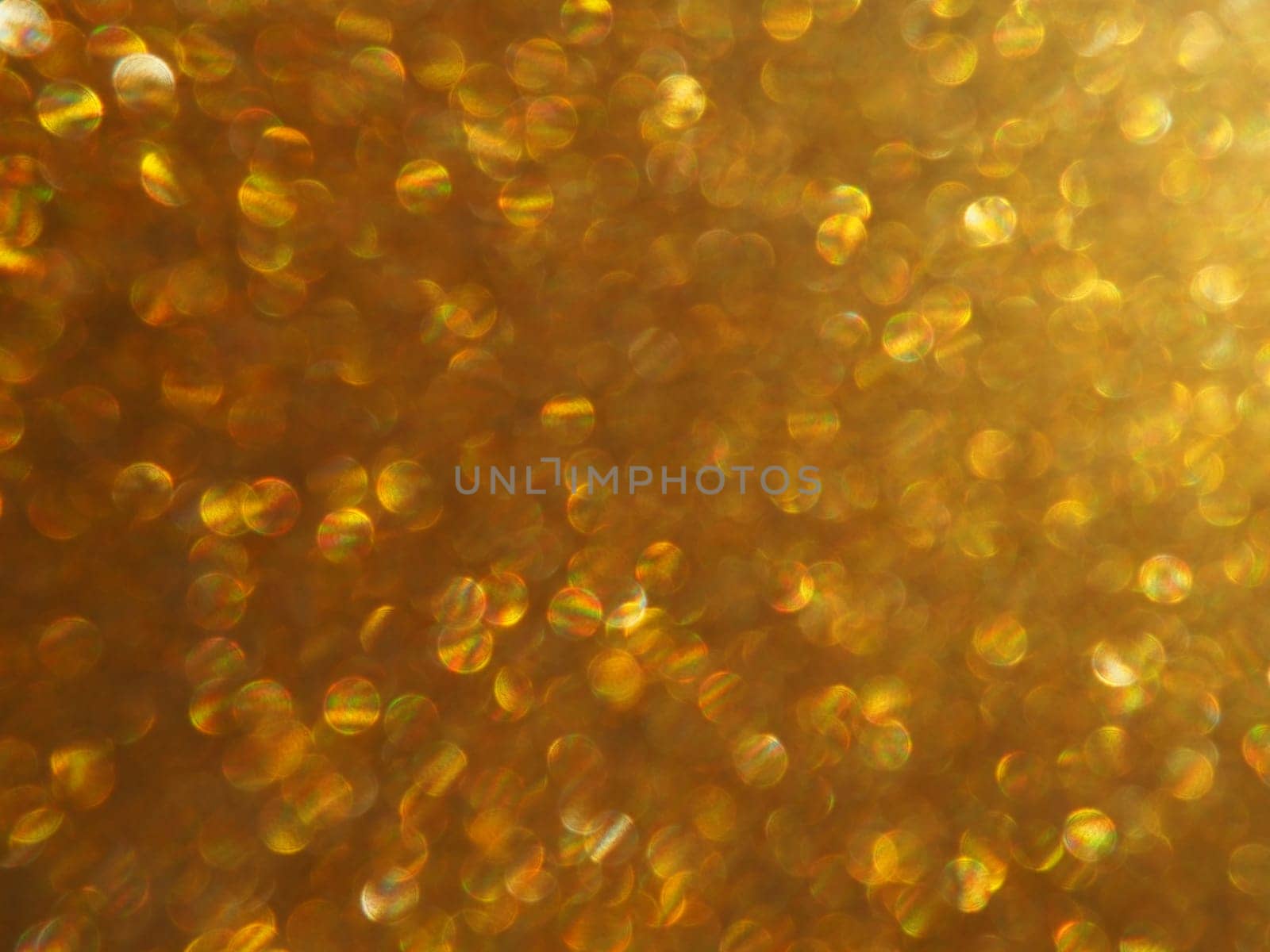 Bokeh light of gold glitters. Golden glitter texture background. Sparkling glitter wrapping paper with sequins and sparkles. Festive golden bokeh and glitter. Beautiful macro background.