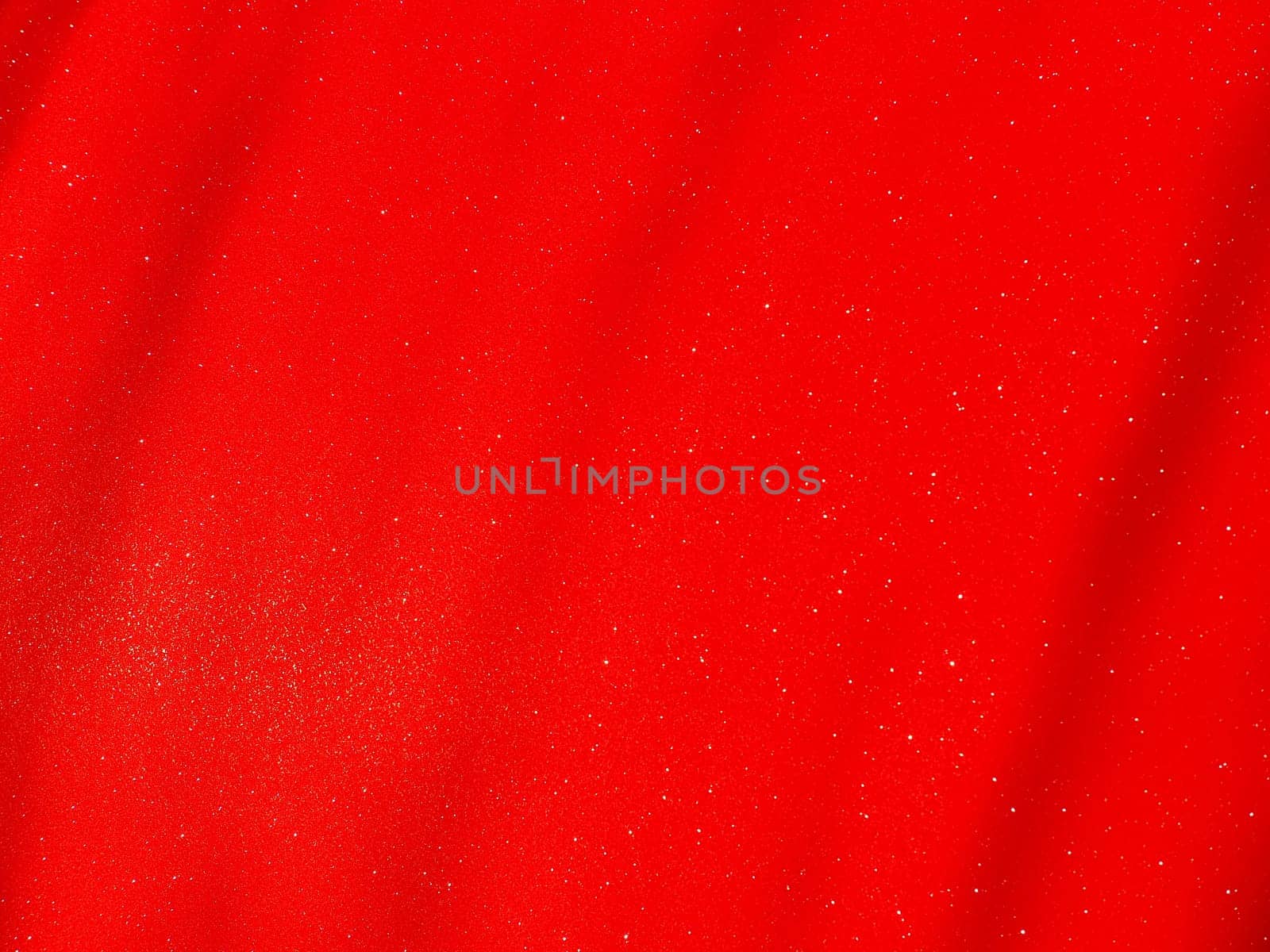 Red background, arched scarlet. Nice holiday color. Background with shimmer, gradient, white dots. Photograph of sparkling colored paper