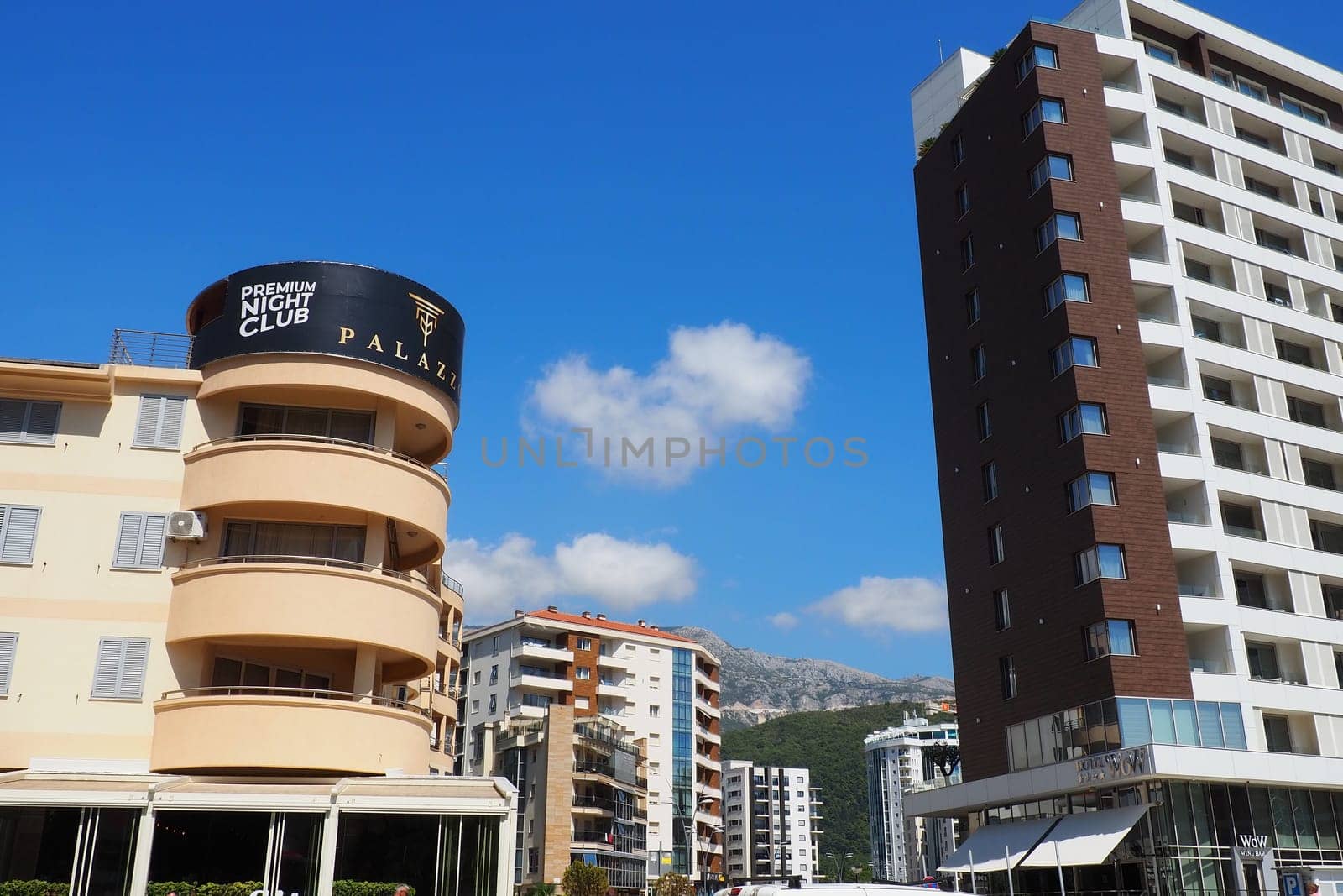 Budva, Montenegro, August 18, 2022. City life of Budva in the summer tourist season. Modern buildings, transport, people on the street go shopping, cafes. Sunny day. Tourism and active lifestyle