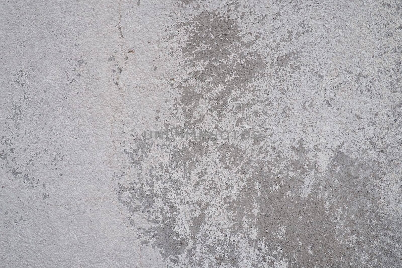 Plastered wall texture. Whitewash surface. Abstract background. Retro wall built structure texture. Cracks and bumps on the concrete wall. Uneven coloring with water-based paint. Old tattered plaster.