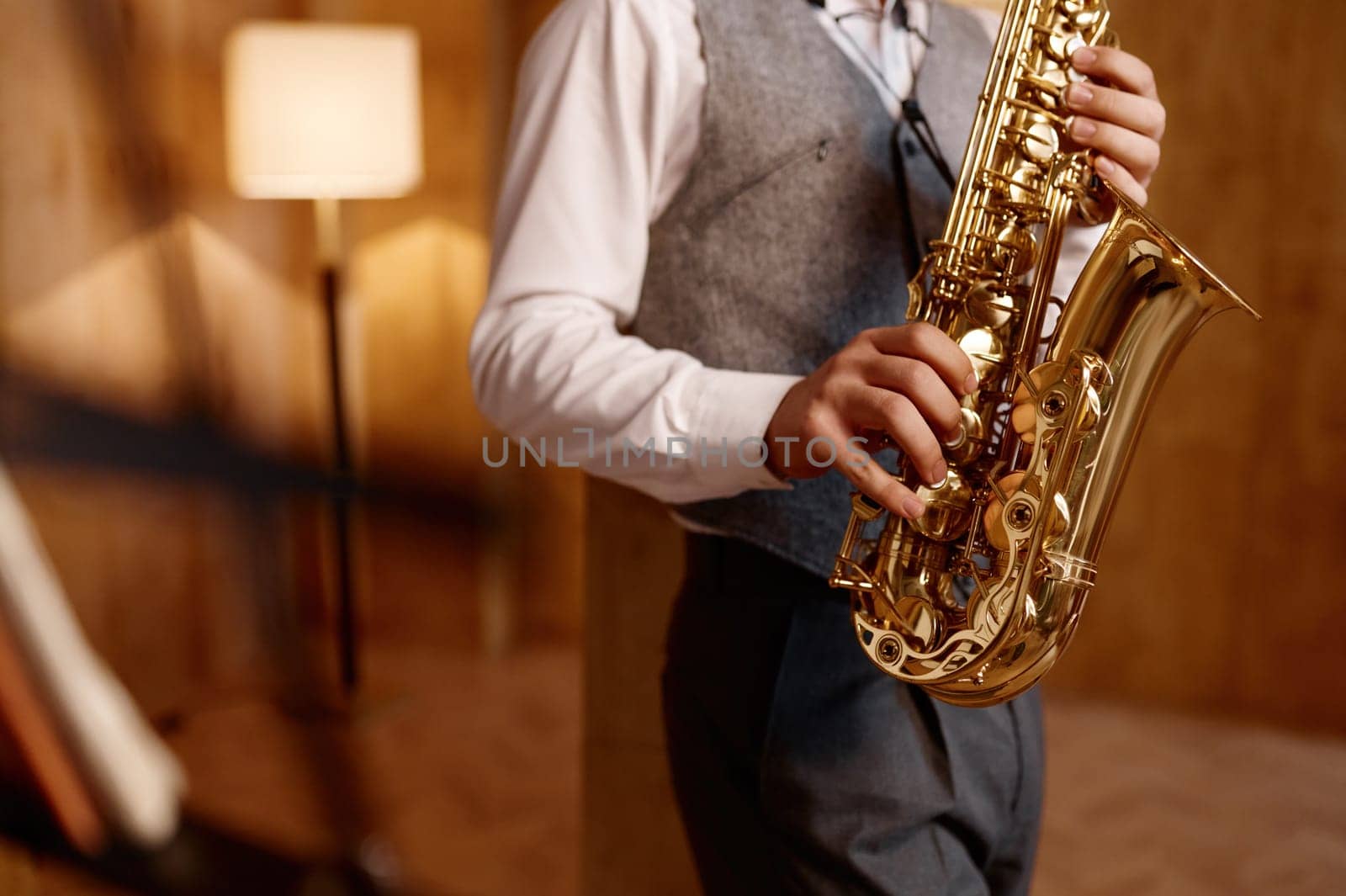 Cropped shot of young musician standing and playing saxophone. Musical jazz or blues performance