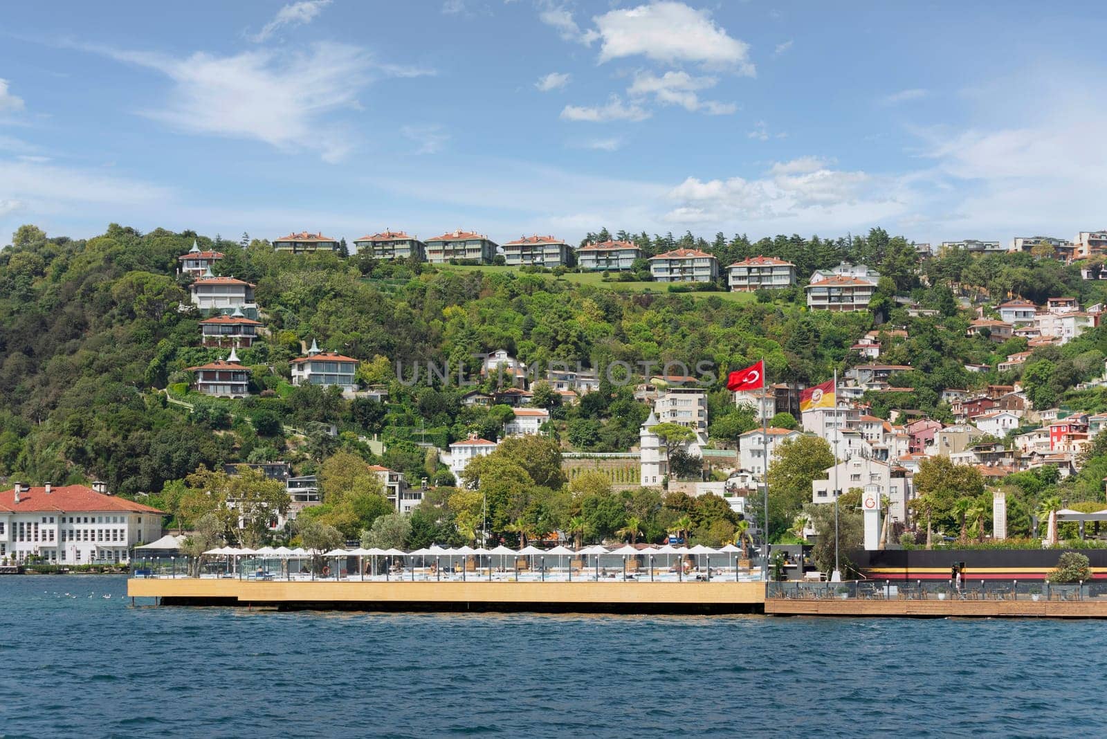 View from the sea of the green mountains of the Europian side of Bosphorus strait, with traditional houses and dense trees, in a summer day, Istanbul, Turkey