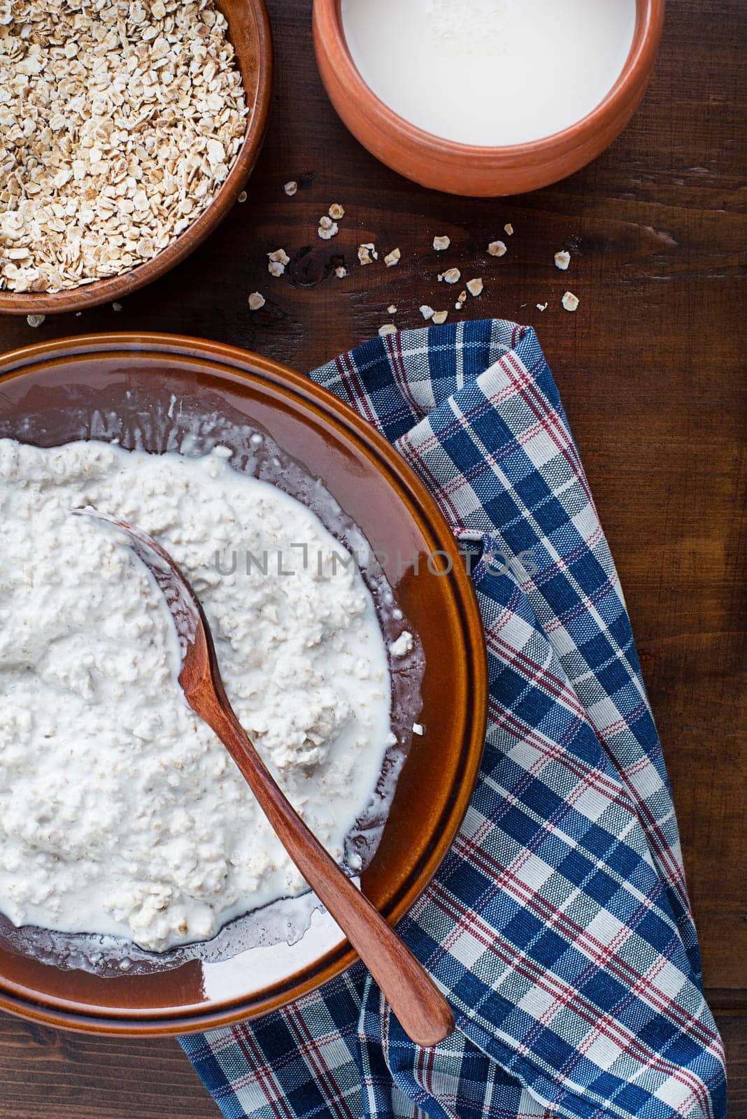 Oatmeal bowl. Cooked oatmeal served with fresh milk. Healthy breakfast food, diet. Top view.