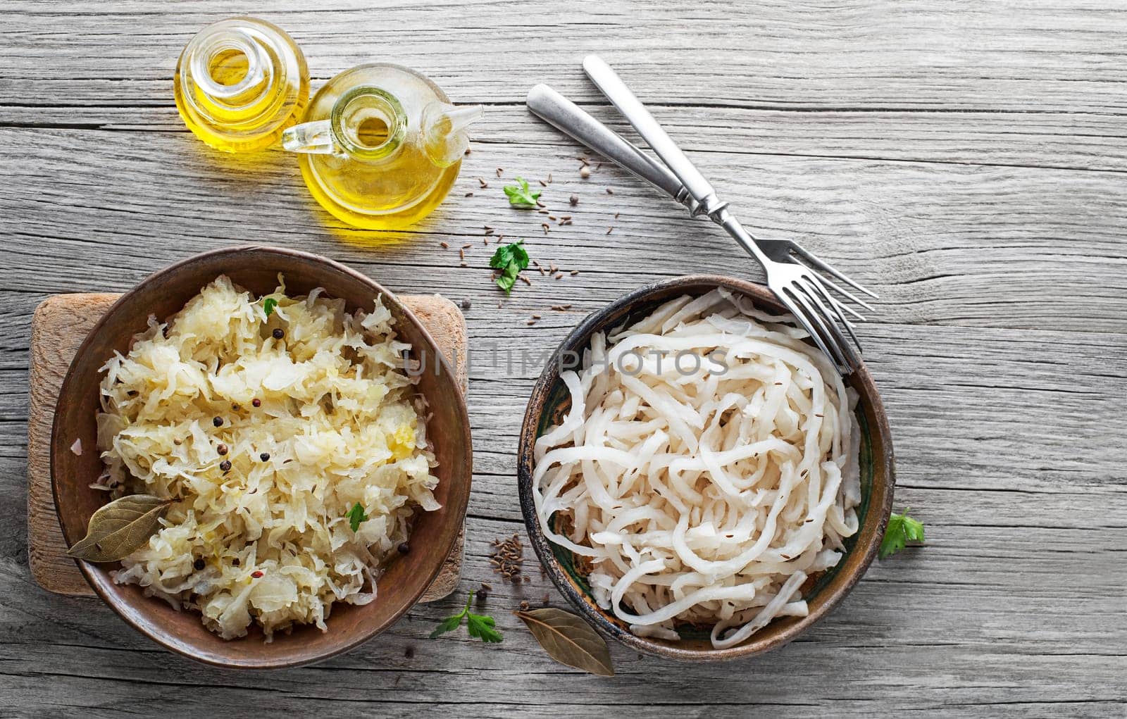 Traditional fresh and healthy sauerkraut and sour turnip on wooden background.