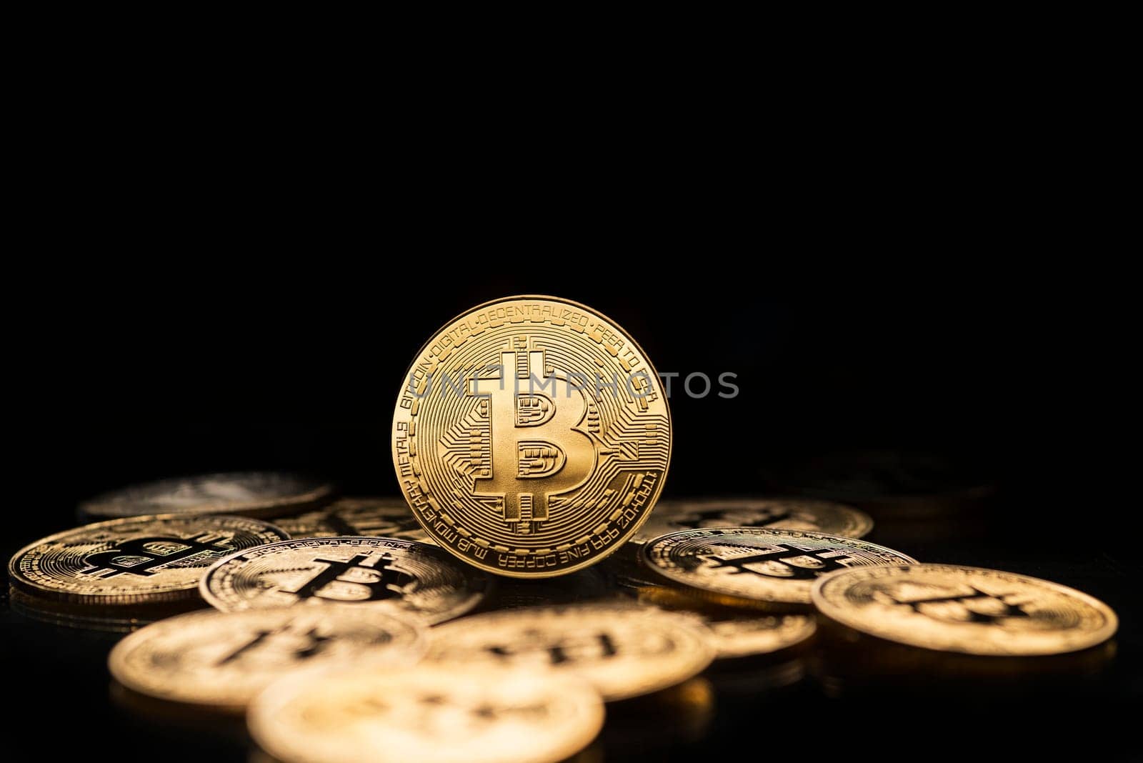 Bitcoin and cryptocurrency investing concept. Bitcoin cryptocurrency symbol with coins on black background. Trading on the cryptocurrency exchange. Trends in bitcoin exchange rates