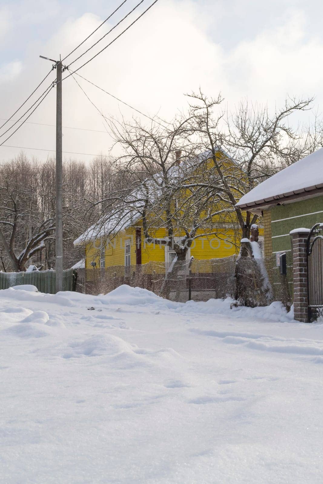 Snowy russian village, village with snowy road and houses.