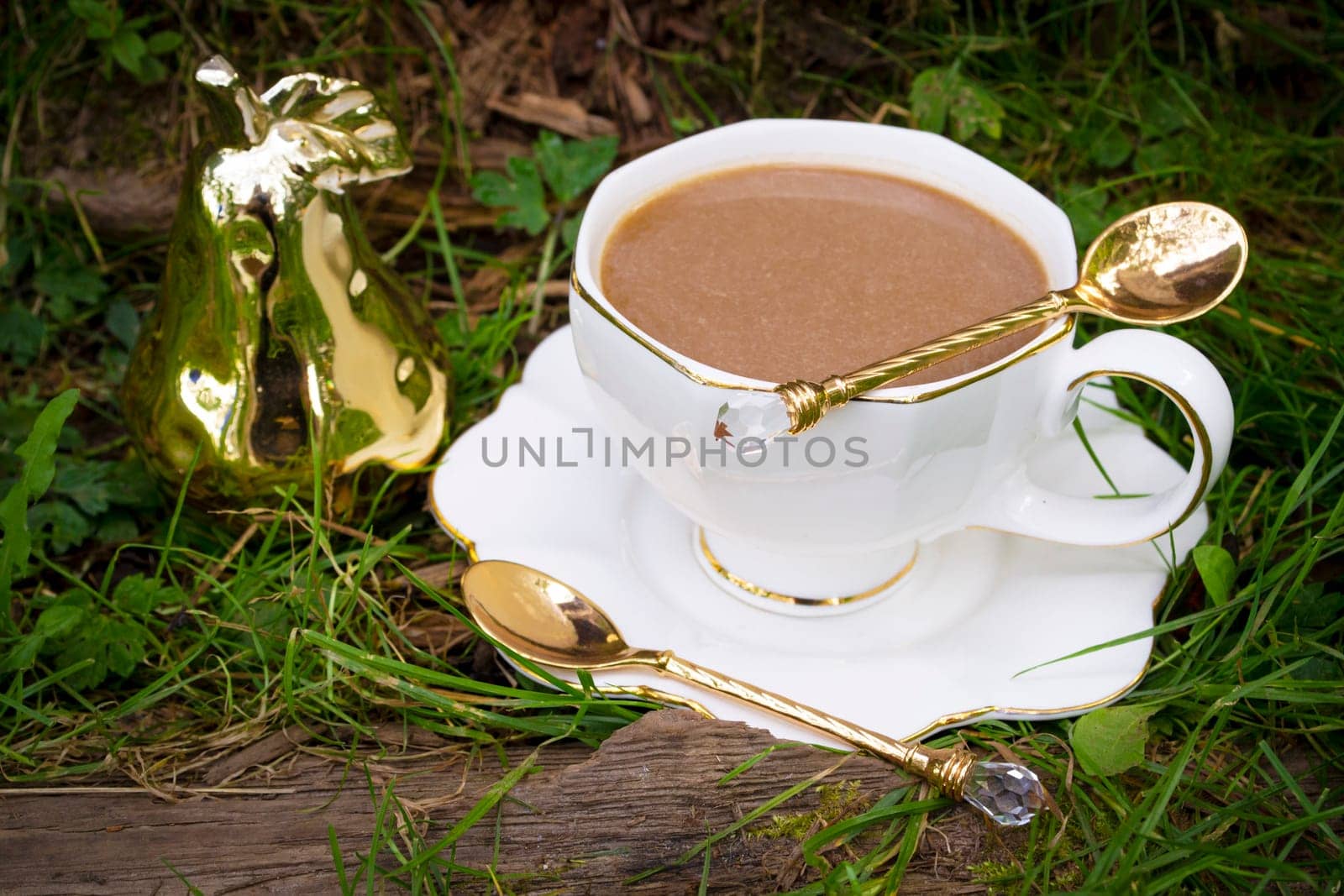 A cup of capuccino in white cup on grass, vintage style