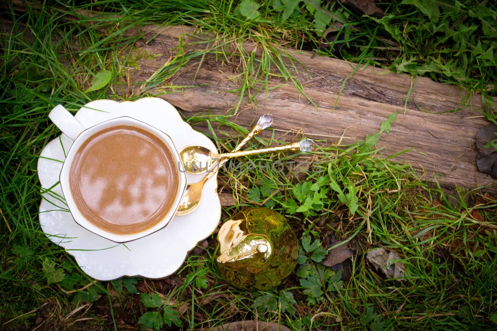 cup of cappuccino on grass. Bright sunny morning, time for rest and coffee drinking. Energy drink, beauty of nature. Cozy atmosphere, relaxation. Flat lay