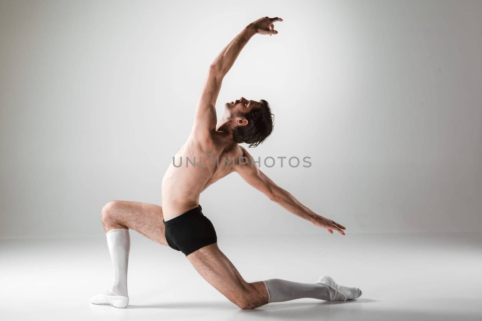 The young attractive modern ballet dancer over white background