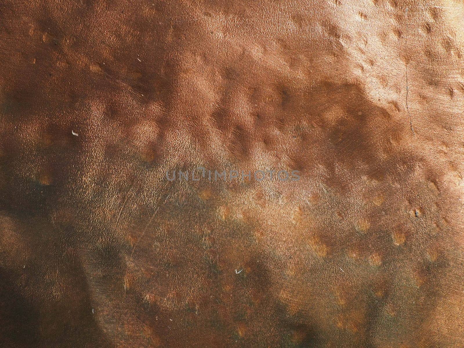 Metal bronze textured plate. Bronze or copper polished surface with dents, scratches and indentations. Metal texture.