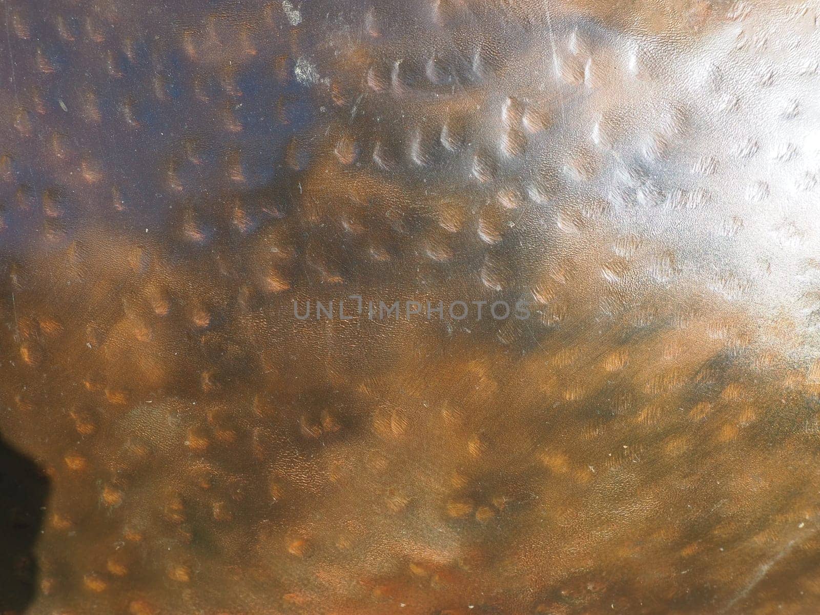 Metal bronze textured plate. Bronze or copper polished surface with dents, scratches and indentations. Metal texture.