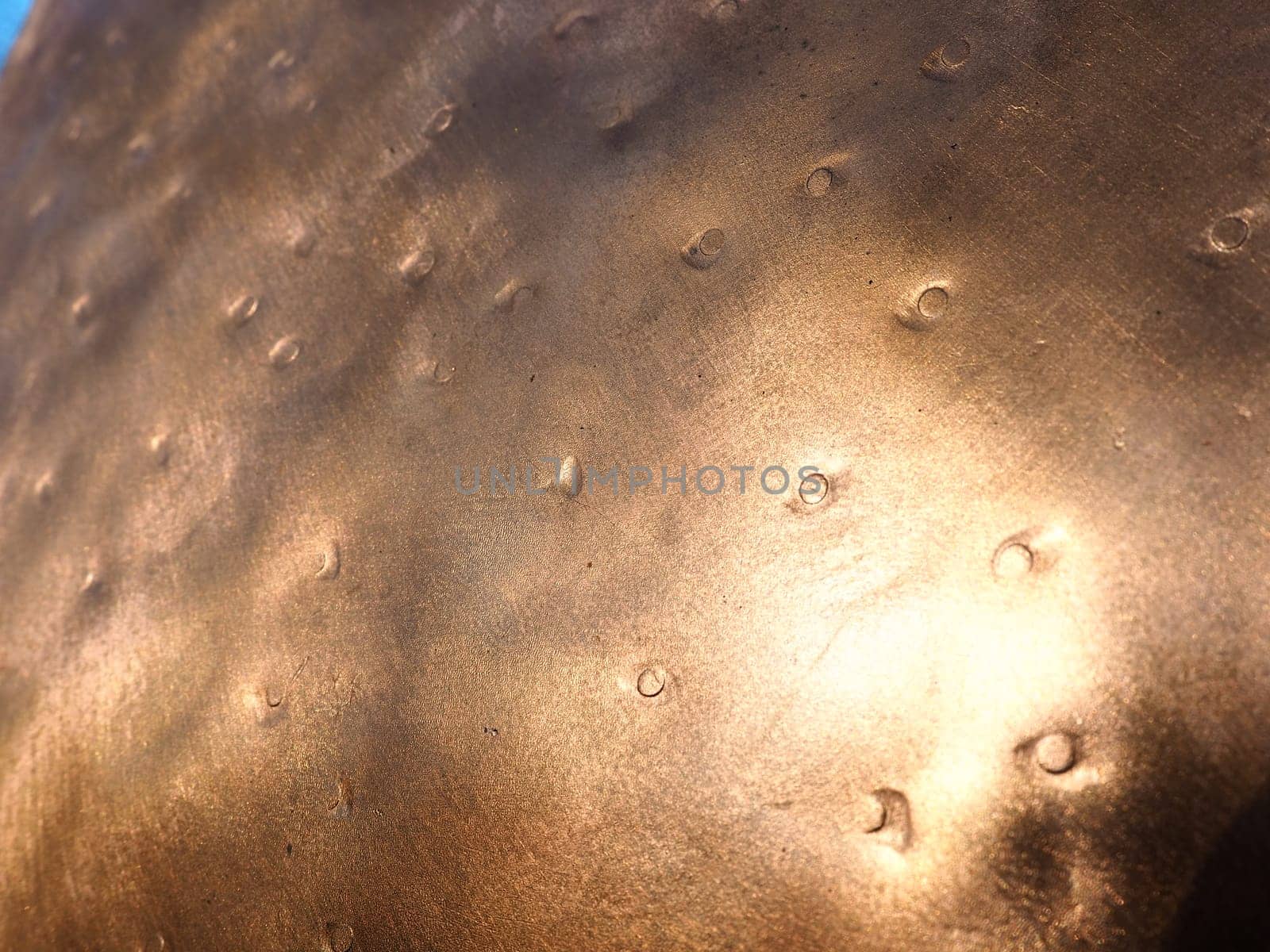 Metal bronze textured plate. Bronze or copper polished surface with dents, scratches and indentations. Metal texture.